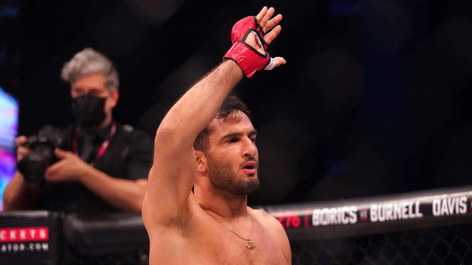 MMA拳手在八角籠內舉手慶祝勝利。