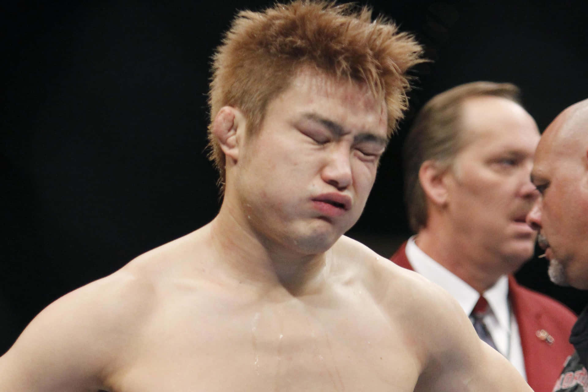 一名男性拳手在搏擊運動比賽中因疲憊而扭曲表情。
