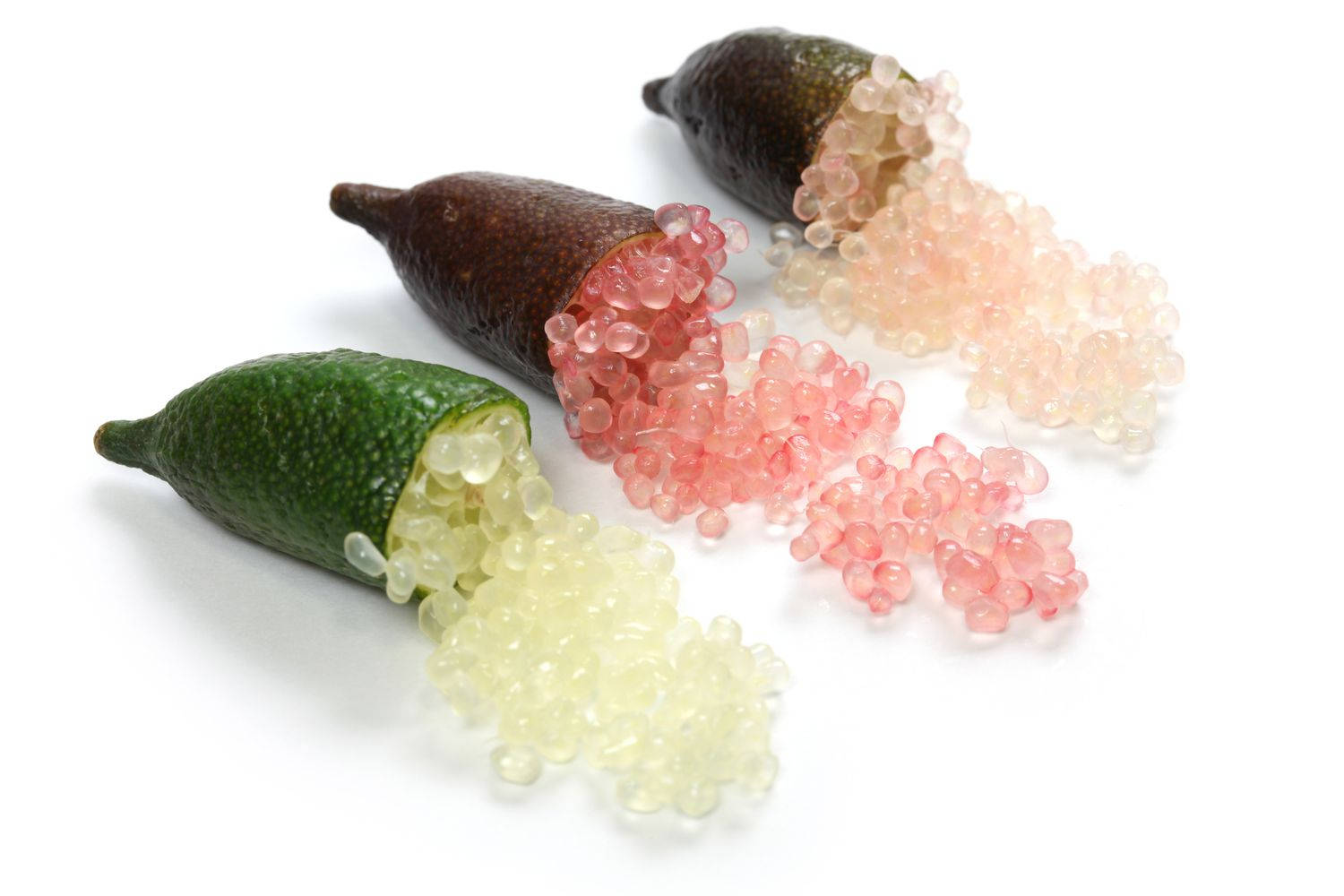 綠、粉、棕三色指 lime 果 壁紙 — 三個手指青檸切開，半透明粉紅色和淡黃色魚子醬般的珍珠灑落在純白表面上。