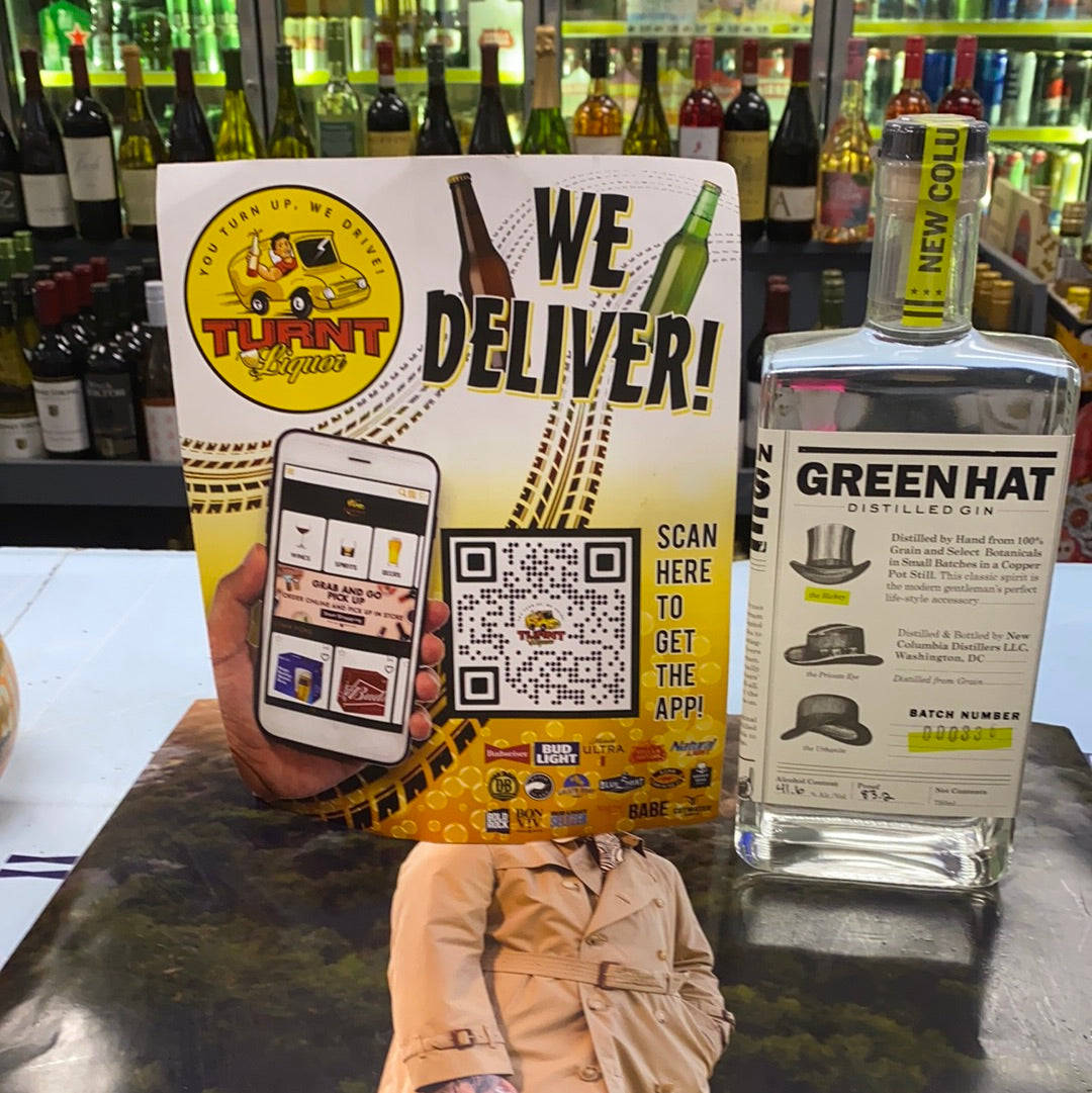酒舖櫃枱展示了一個送貨廣告和一瓶帶有風衣倒影的氈酒。