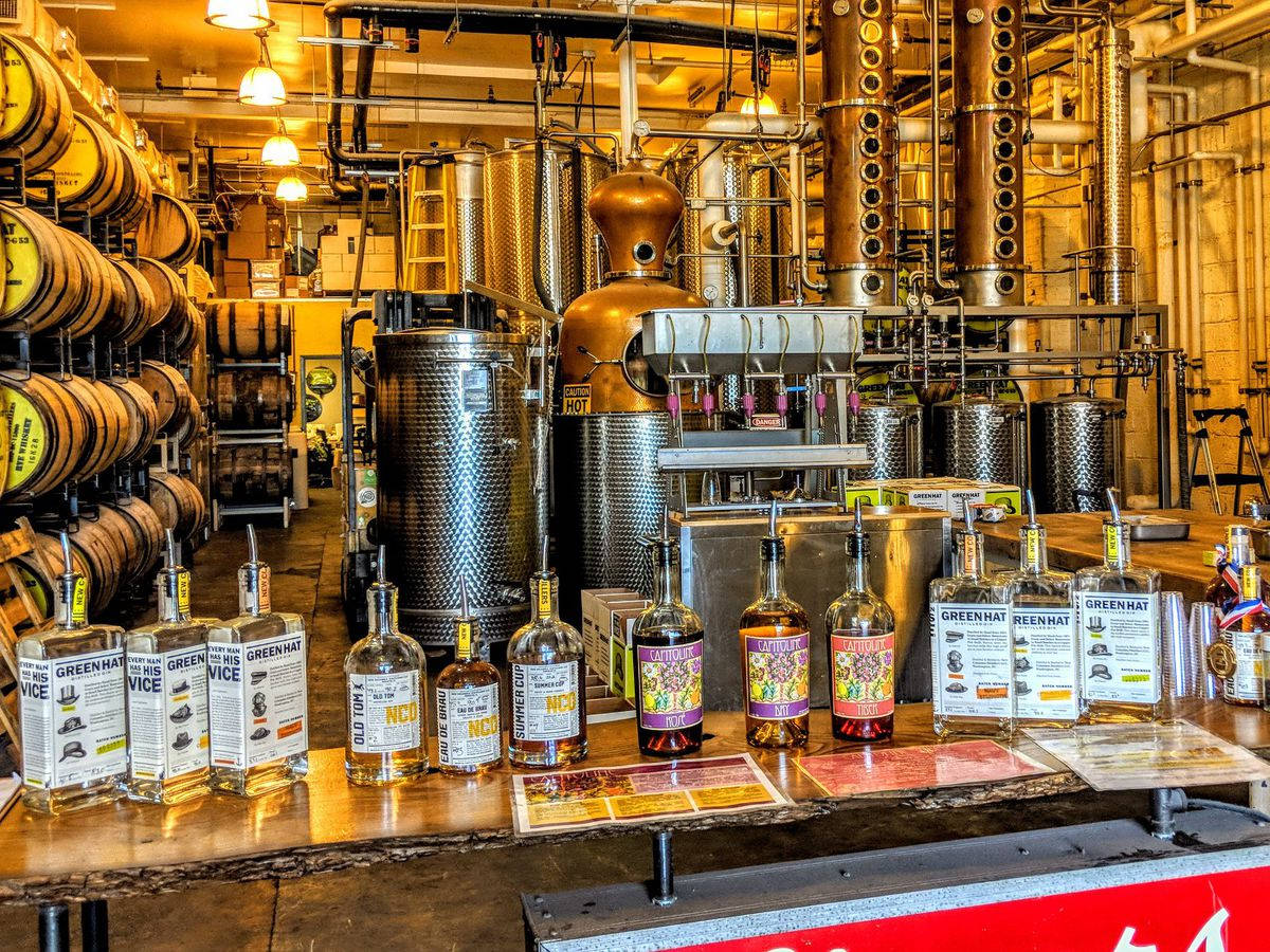 蒸餾廠內有銅製蒸餾器、木桶和櫃檯上的酒瓶。