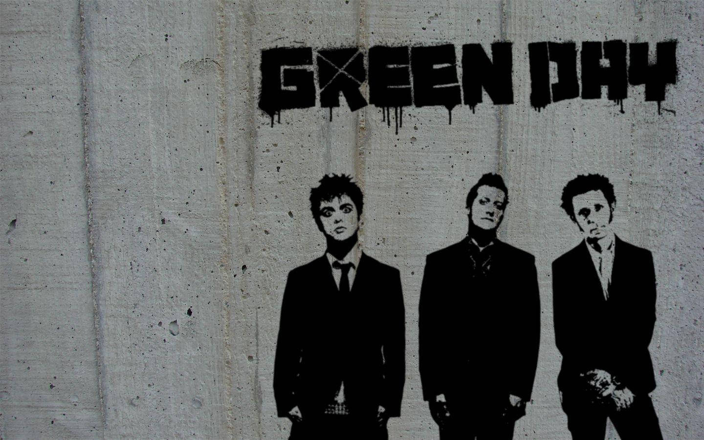 綠日樂隊塗鴉 stencil 藝術 壁紙 — 三名穿西裝的男子站在一個滴落的「GREEN DAY」塗鴉標籤下方，背景是風化的混凝土牆。