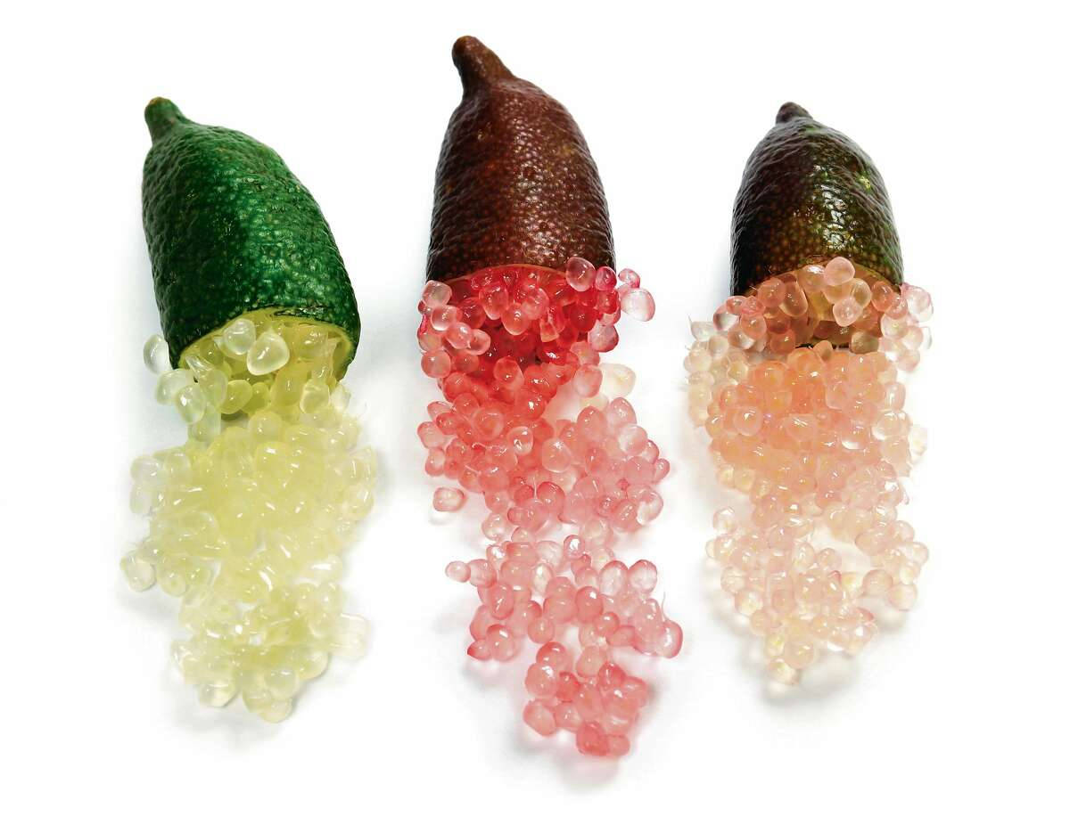 綠紅棕三色指 lime 壁紙 — 三個金桔切開，露出閃閃發光的半透明種子，散落在純白背景上。
