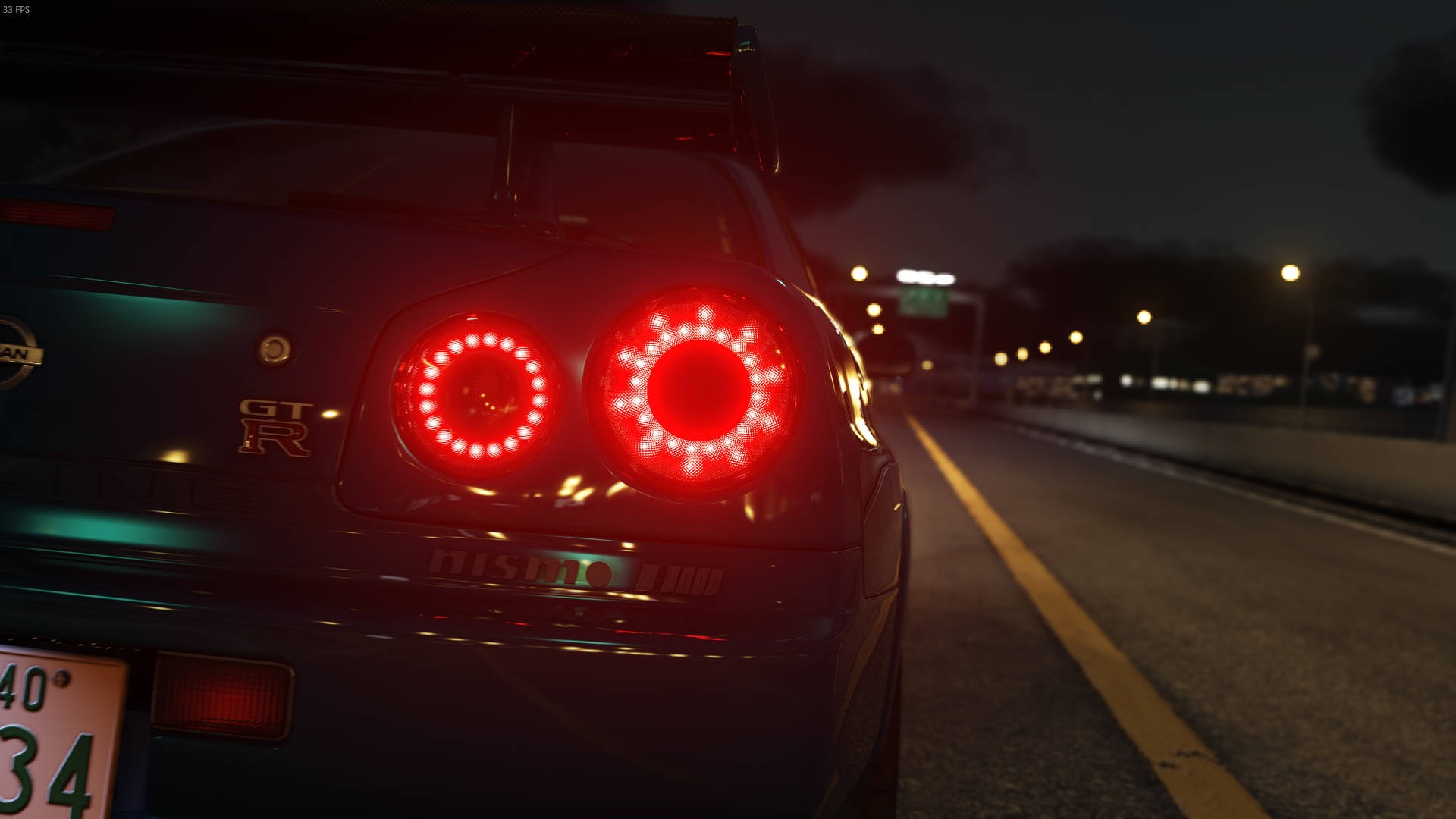 綠色 Nissan Skyline GTR R34 後視圖 壁紙 — 一輛深色日產GT-R，帶有發光的紅色圓形尾燈，在夜間沿著昏暗的高速公路飛馳。
