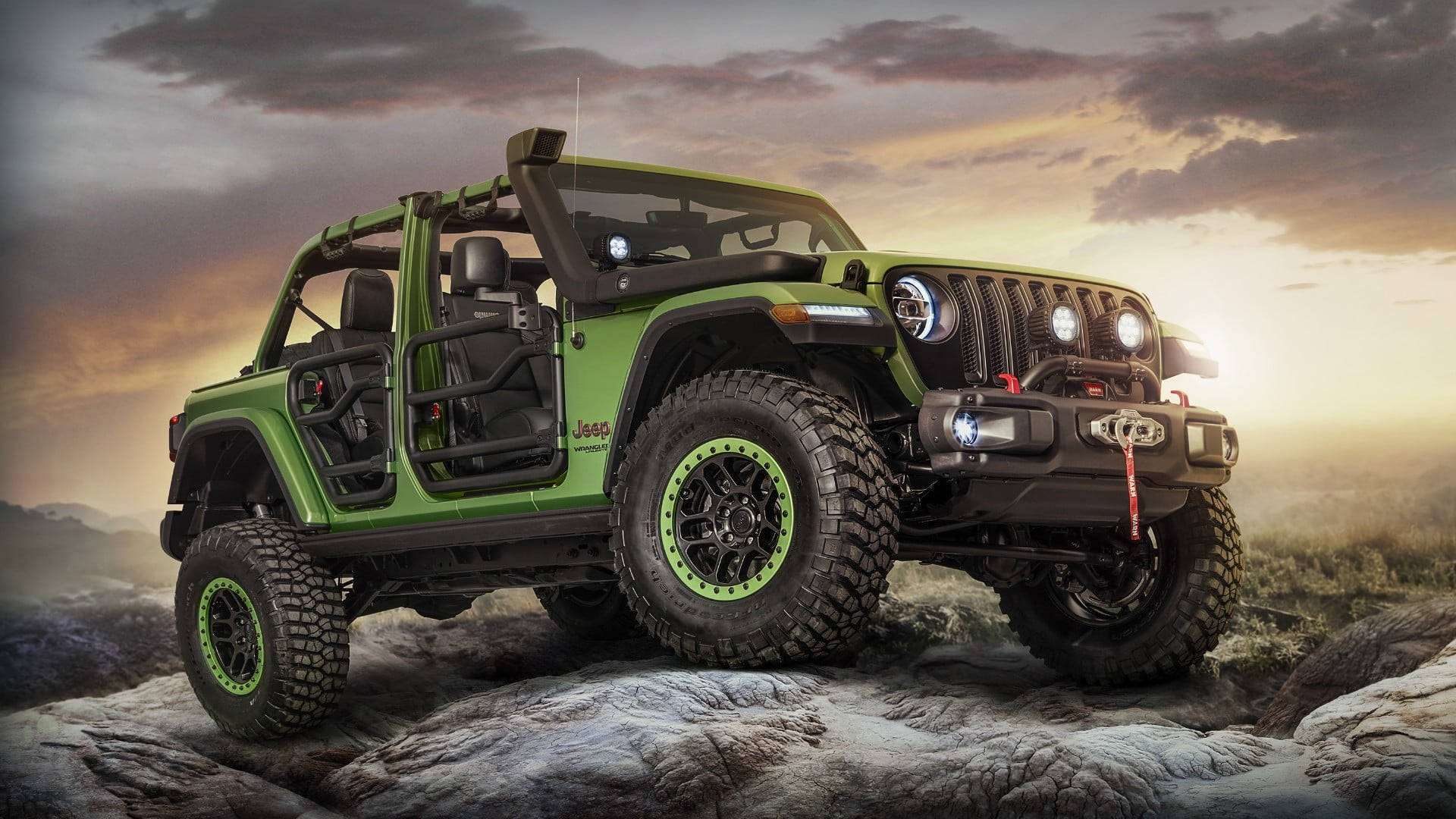 日落時岩石地形上的綠色Jeep Wrangler