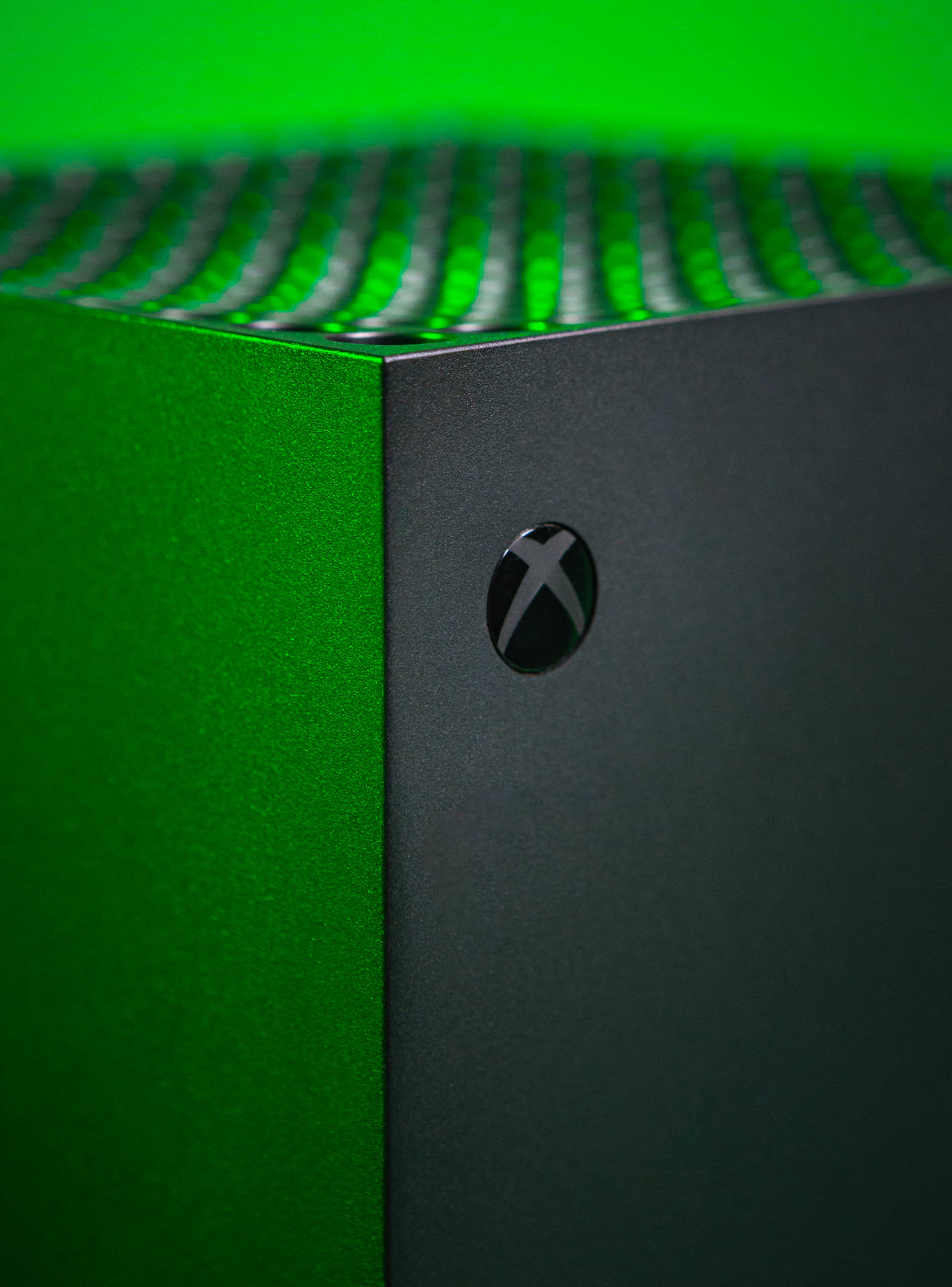 綠色Xbox遊戲主機特寫，帶有發光通風口。