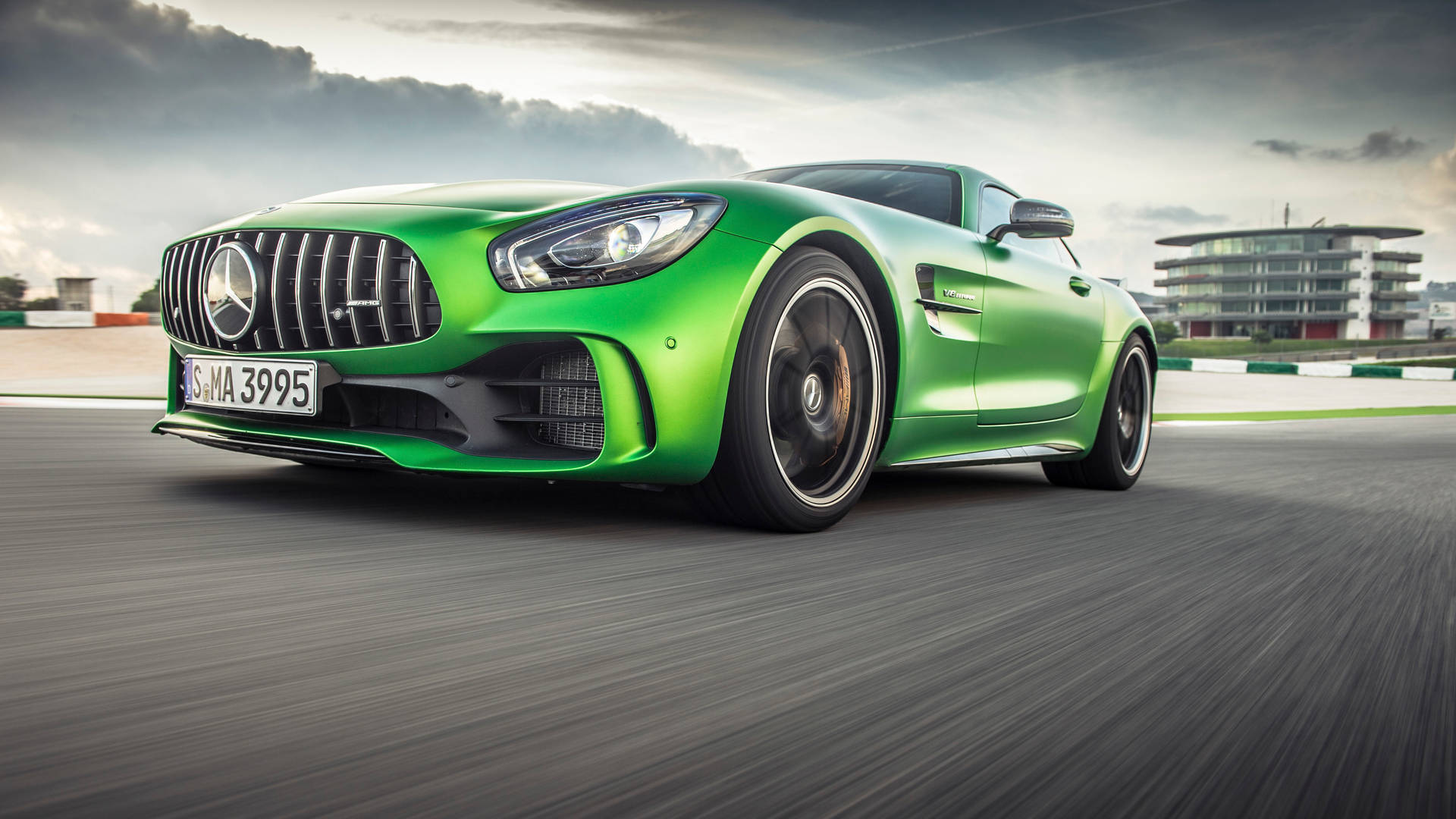 綠色Mercedes-AMG GT S在賽道上疾馳，帶有動態模糊效果。