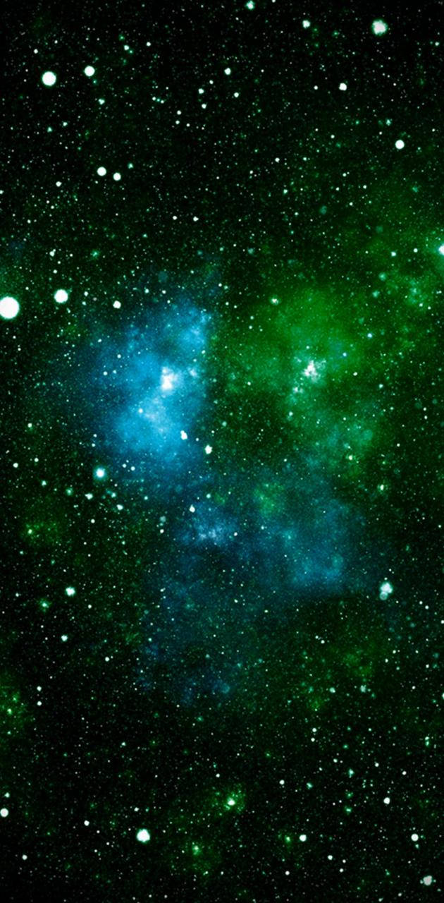 深空中充滿星星的鮮豔綠色和藍色星雲。