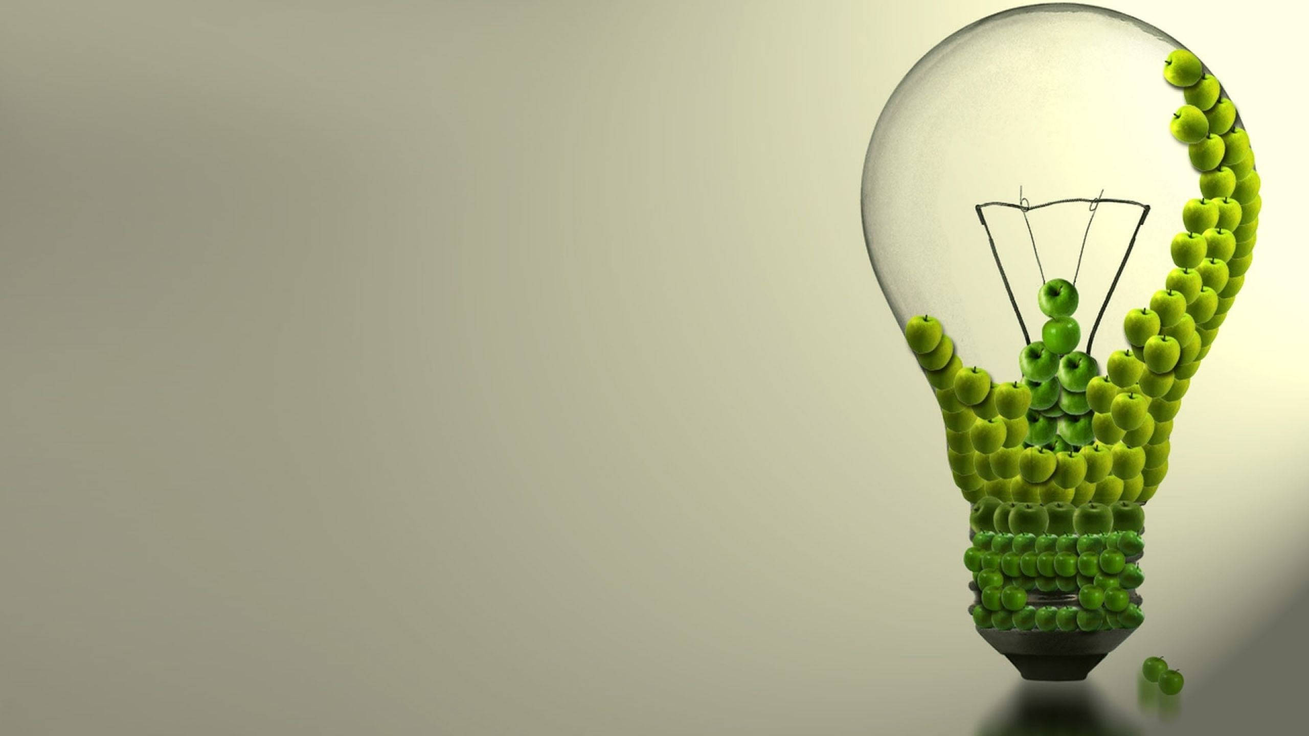 綠蘋果電力燈泡 壁紙 — 一個由青蘋果組成的透明燈泡，內部有金屬絲燈絲，背景為柔和的米色。