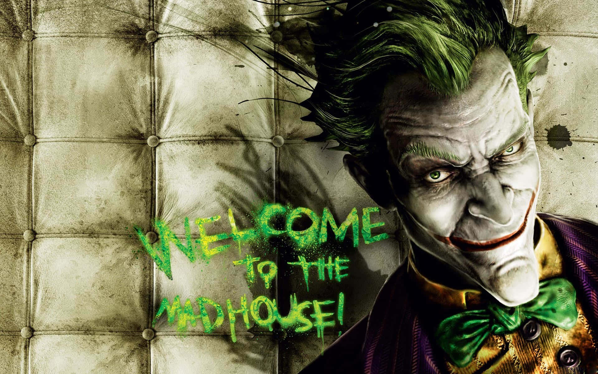 Welcome Gaming 桌布 壁紙 — 綠髮咧嘴笑的小丑靠在一張簇絨皮革沙發上，塗鴉寫著「歡迎來到瘋人院」。