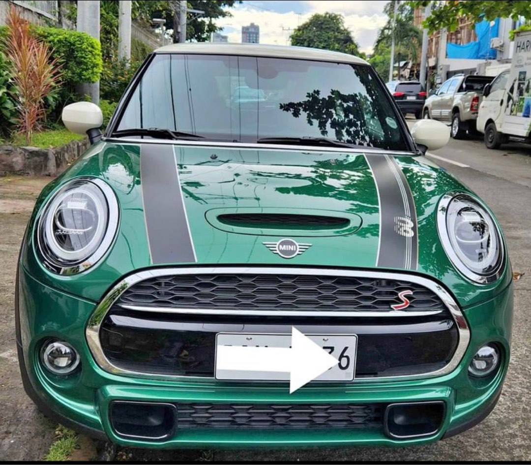 綠黑配色迷你車正面視角 壁紙 — 一輛充滿活力的綠色MINI Cooper S，帶有黑色賽車條紋，停在綠樹成蔭的城市街道上。