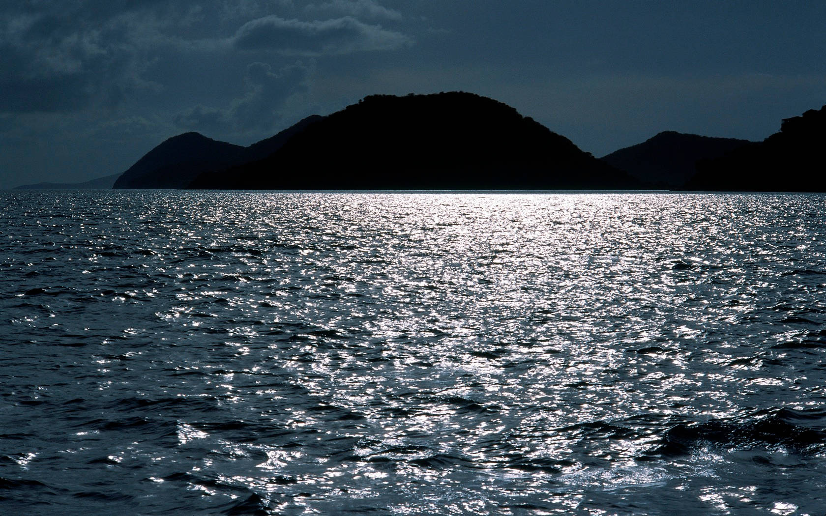 維京群島剪影山脈 壁紙 — 剪影般的島嶼從閃爍的暗海中升起，籠罩在憂鬱的暮色天空下。