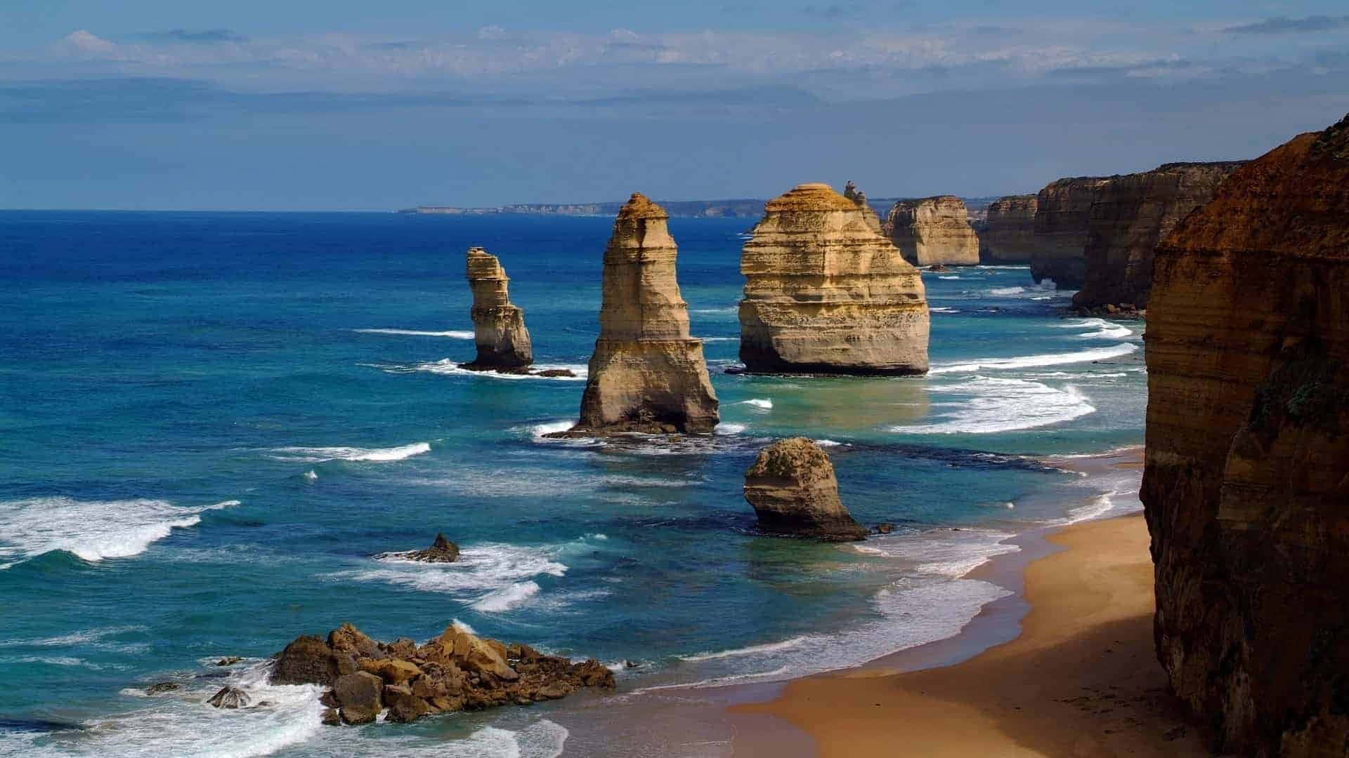 碧綠色海洋和沙灘的海岸懸崖和岩石 formations。