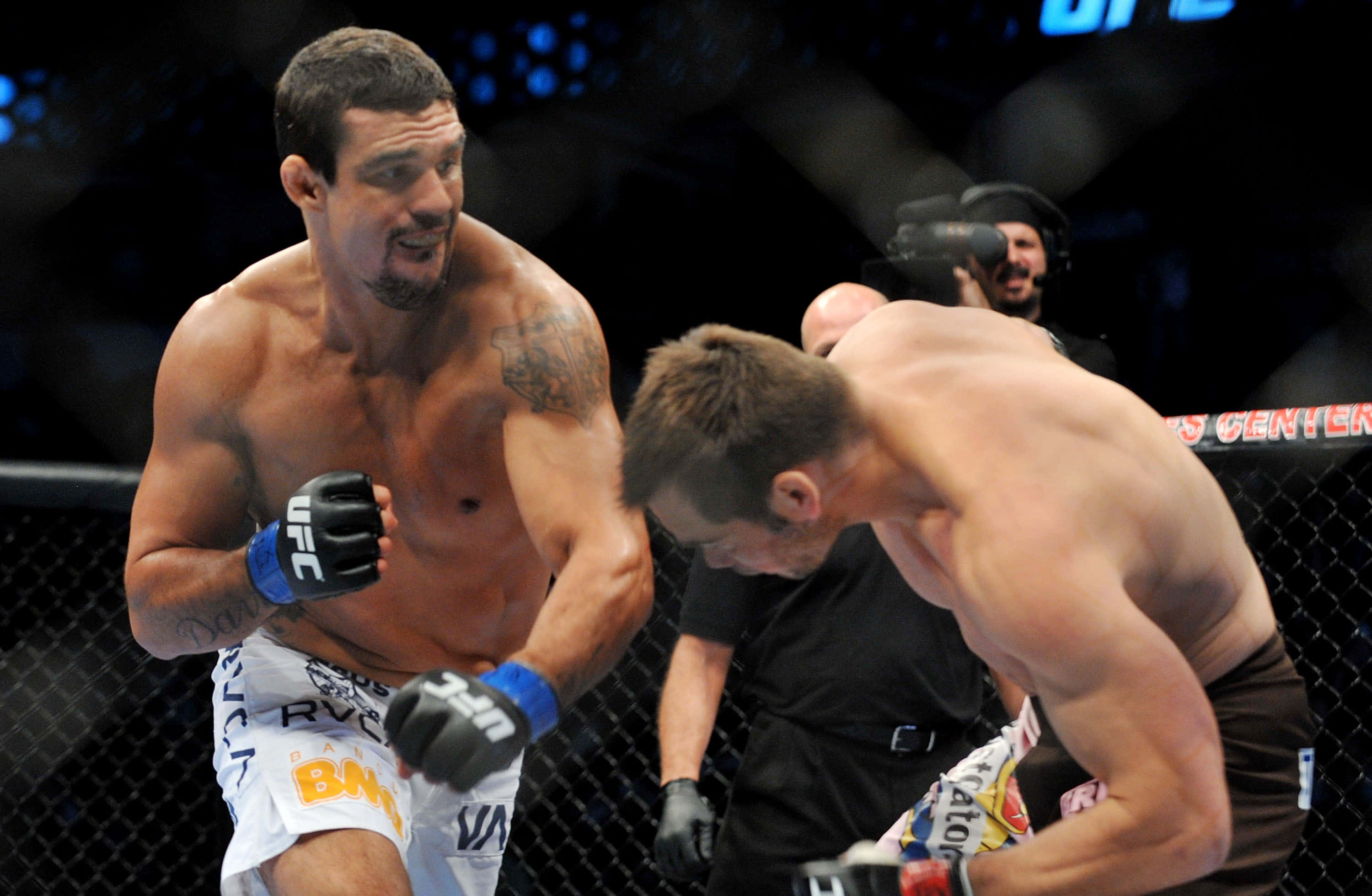 維托·貝爾福特對戰里奇·弗蘭克林 UFC 103 壁紙 — 兩名肌肉發達的MMA拳手在明亮的場館燈光下於UFC八角籠內激烈交鋒。