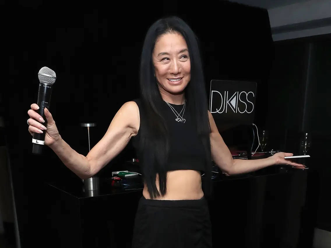 微笑女性在帶有DJ KISS標誌的DJ台拿著麥克風和平板電腦。
