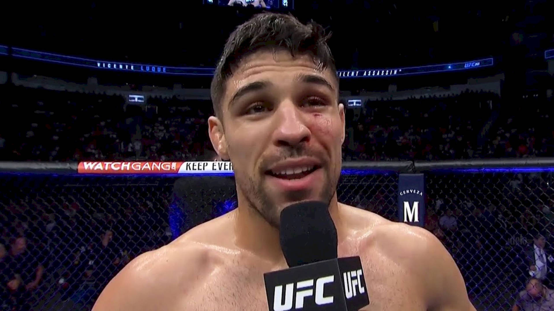 UFC拳手臉頰上有傷口，在八角籠中進行賽後訪問時微笑。