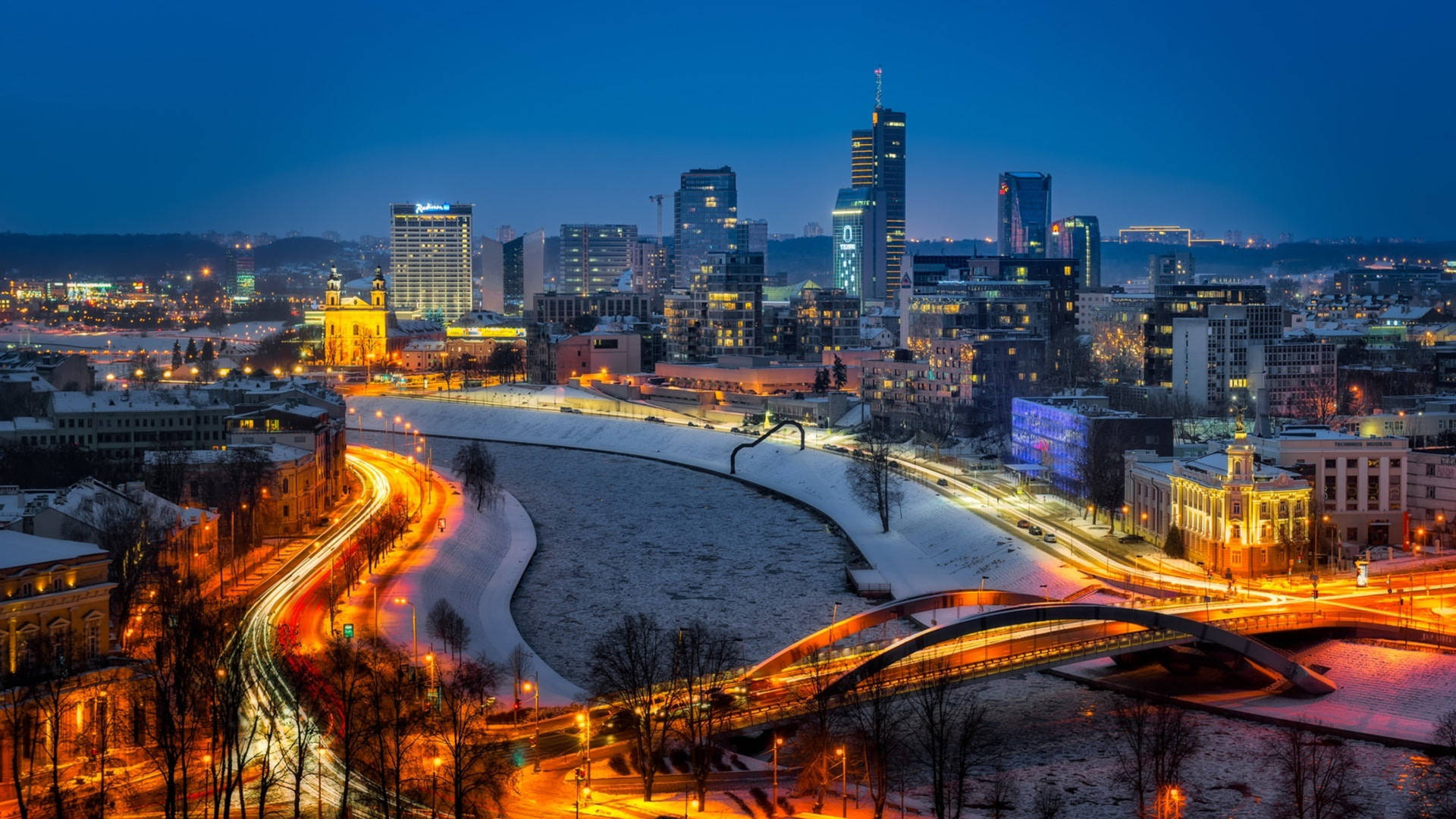 黃昏時分的雪城，發光的車流痕跡和燈火通明的建築。