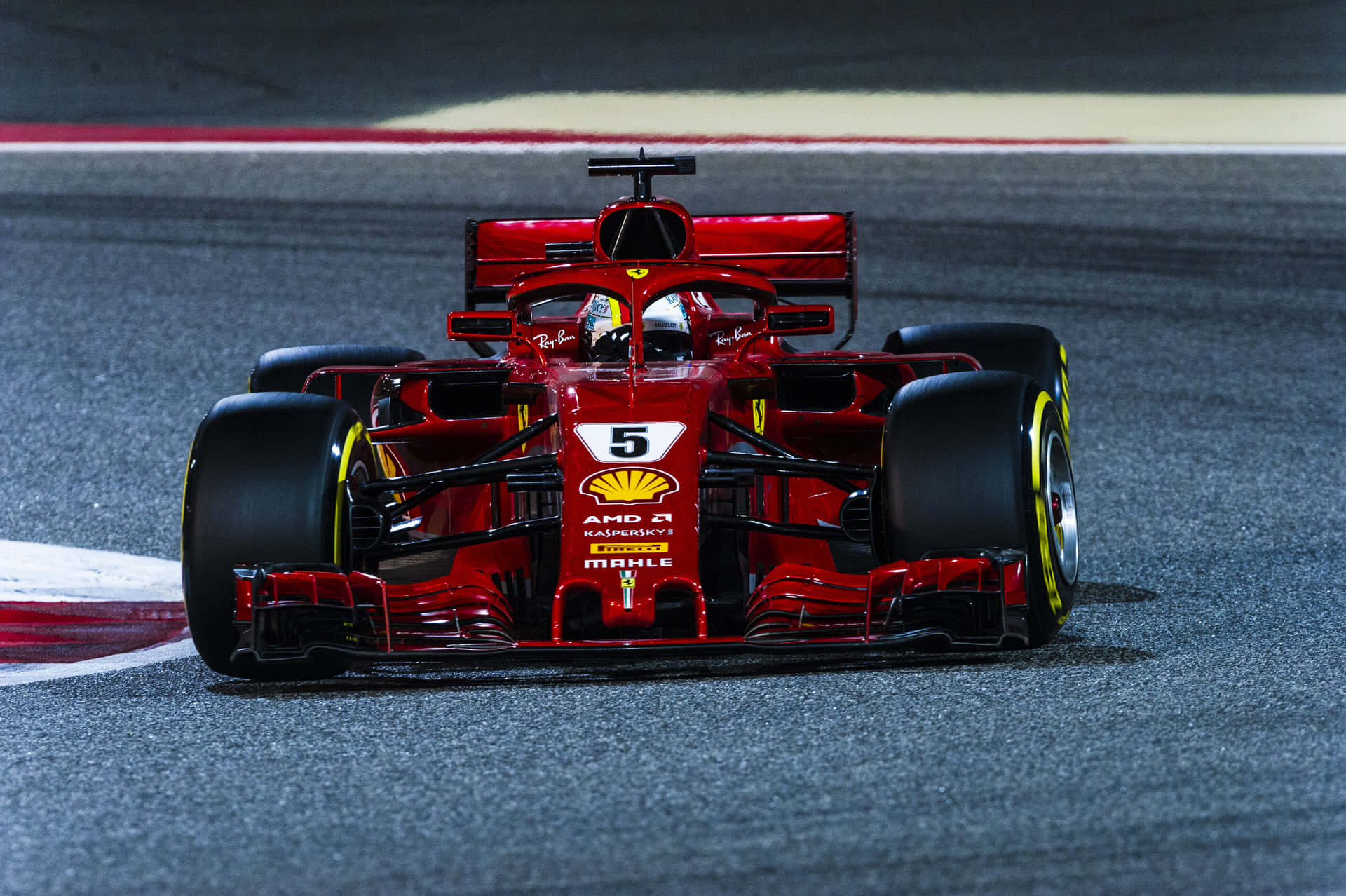 紅色法拉利F1賽車在夜間潮濕的賽道上奔馳。
