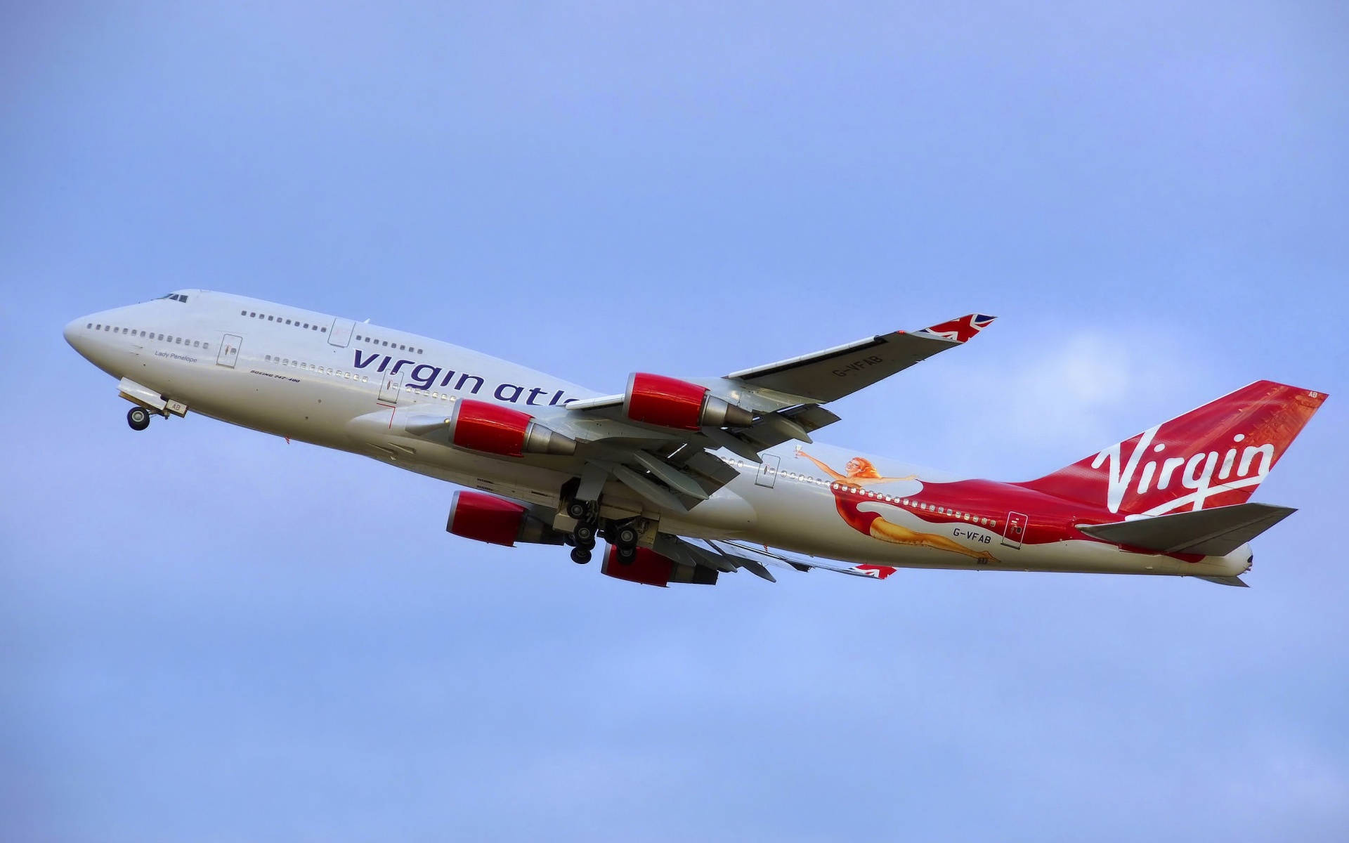 維珍航空飛機在藍天中飛行，起落架已放下。