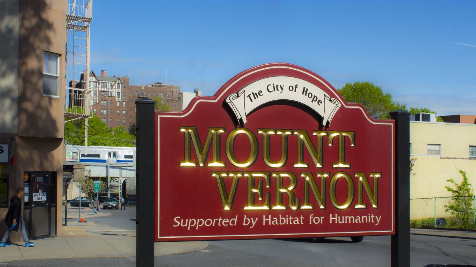 陽光明媚的城市街道上紅金色的 Mount Vernon 城市標誌。