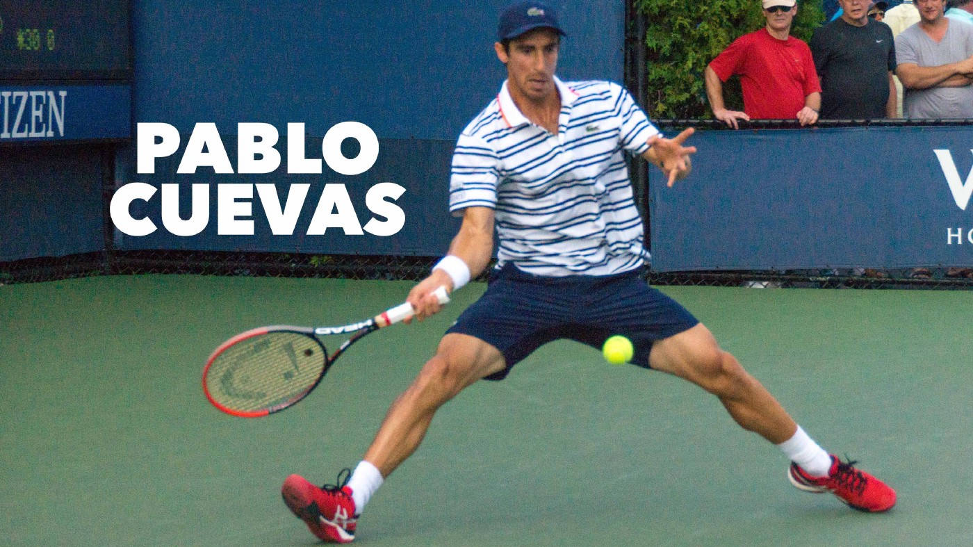 網球選手巴勃羅·庫埃瓦斯 壁紙 — 網球運動員Pablo Cuevas在綠色球場上向前猛衝，以高度專注力擊打黃色球。