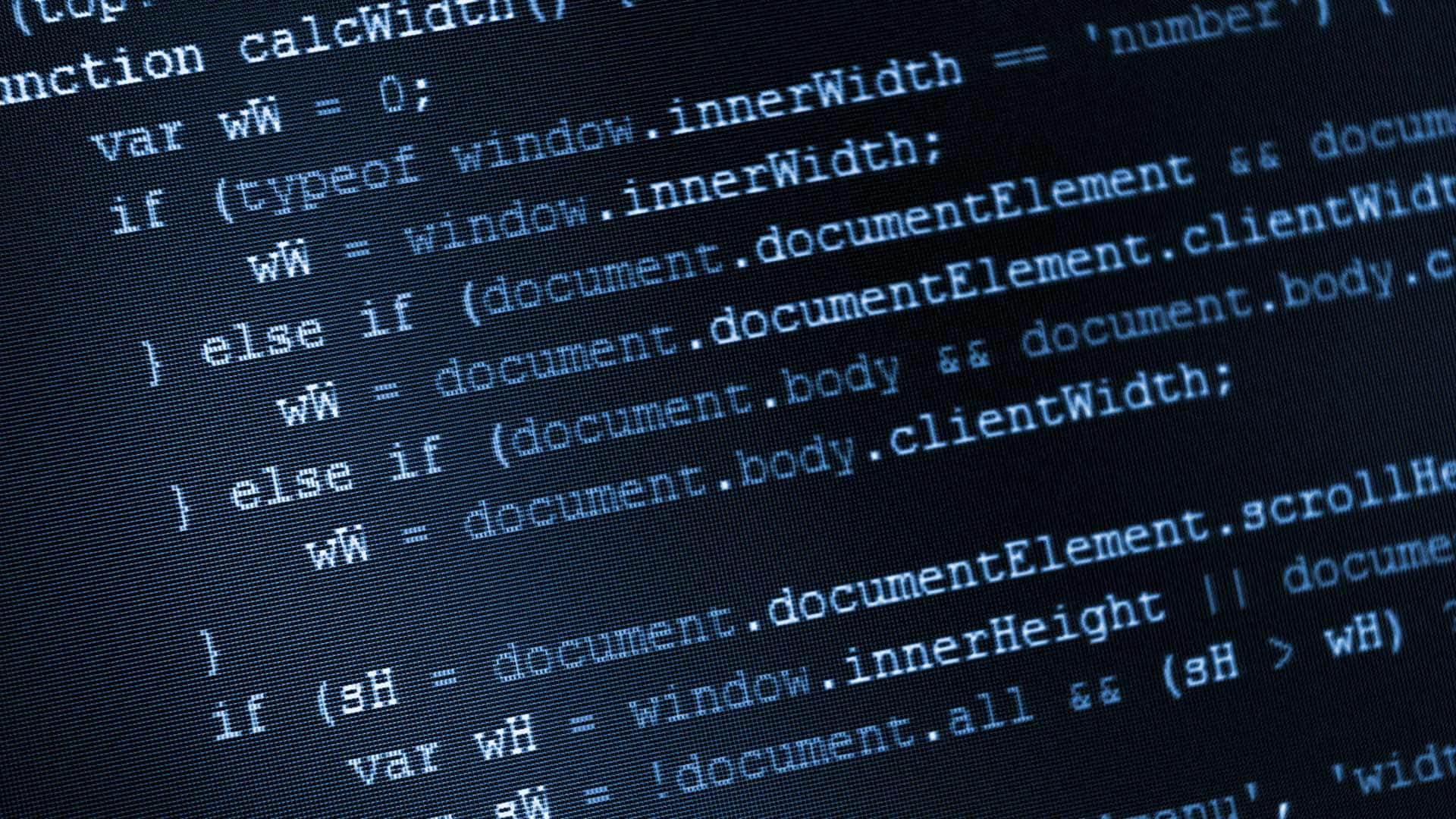 暗色電腦顯示器螢幕上滾動的藍色 JavaScript 程式碼。