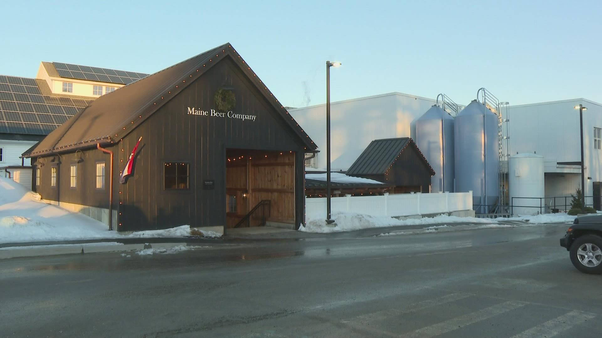 Maine Beer Company 啤酒廠，有雪和大型罐，日落時分。
