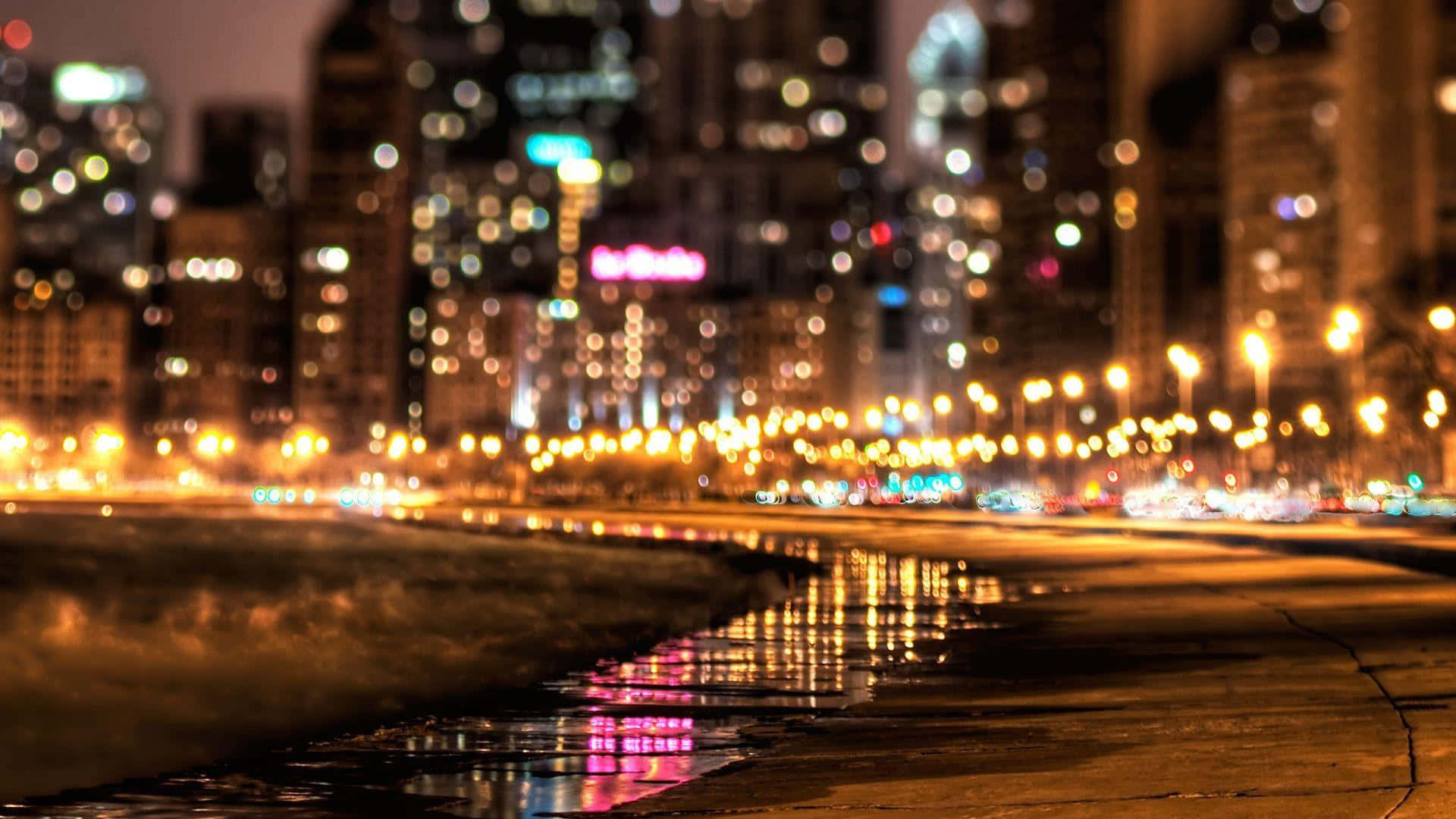 夜間城市燈光反射在濕漉漉的路面上，帶有散景效果。