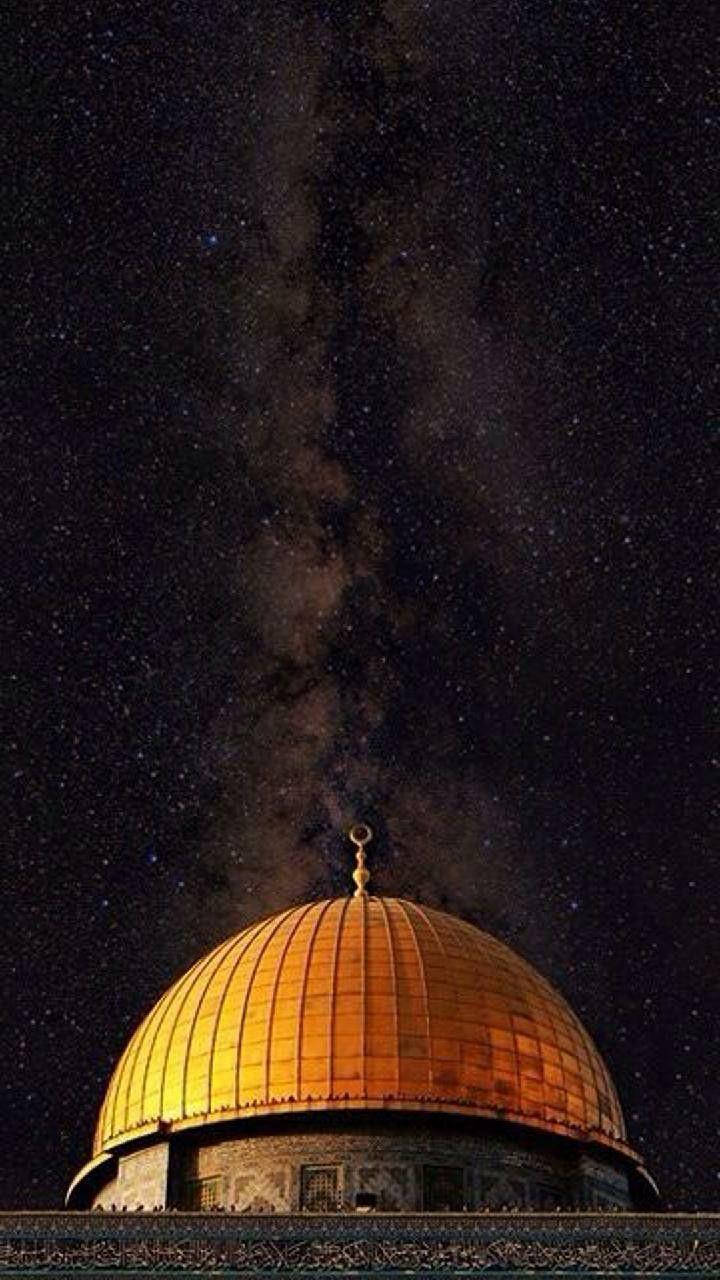 繁星點點夜空下的金色圓頂岩石，銀河可見。