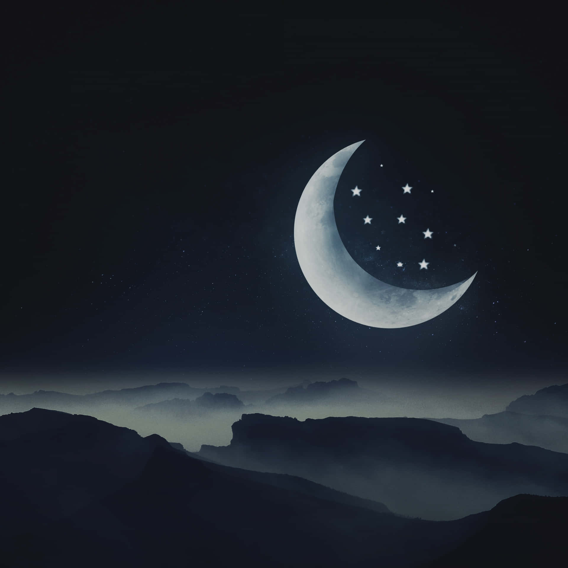 新月和星星在夜霧籠罩的山峰上