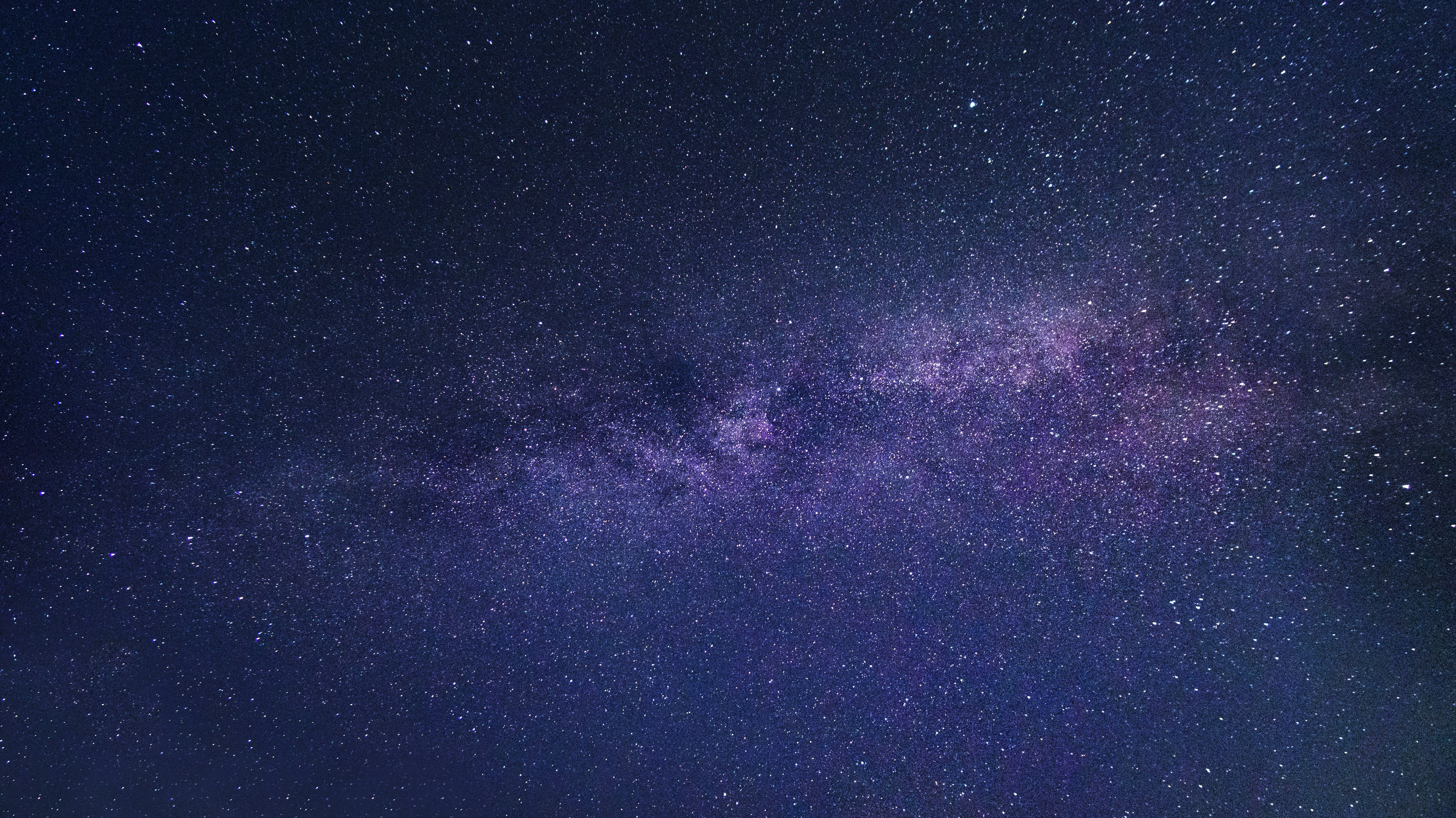 繁星夜空螢幕保護 壁紙 — 令人嘆為觀止的銀河系景觀，在繁星點點的夜空中散發著紫色和藍色的光芒。