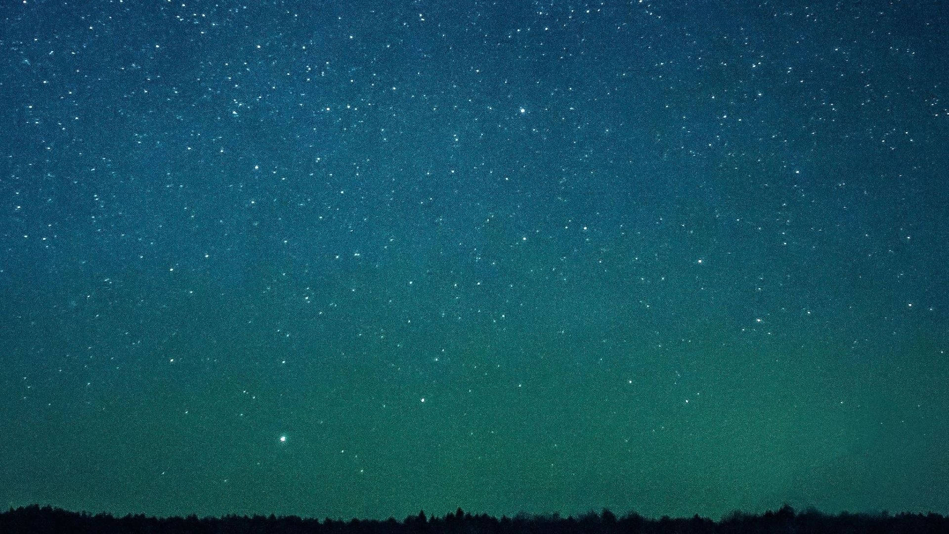 繁星滿天夜景 壁紙 — 在黑暗森林剪影上方，帶有青綠色和深藍色色調的星空夜空。