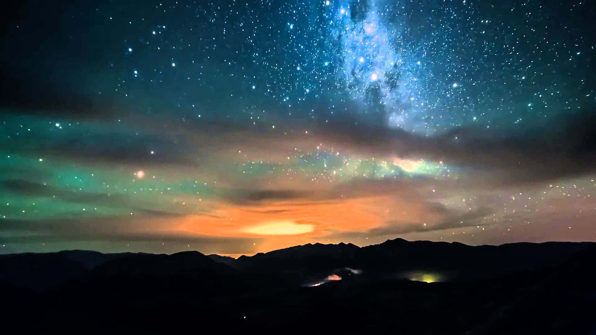 星空下，極光映照著黑暗的山巒剪影。