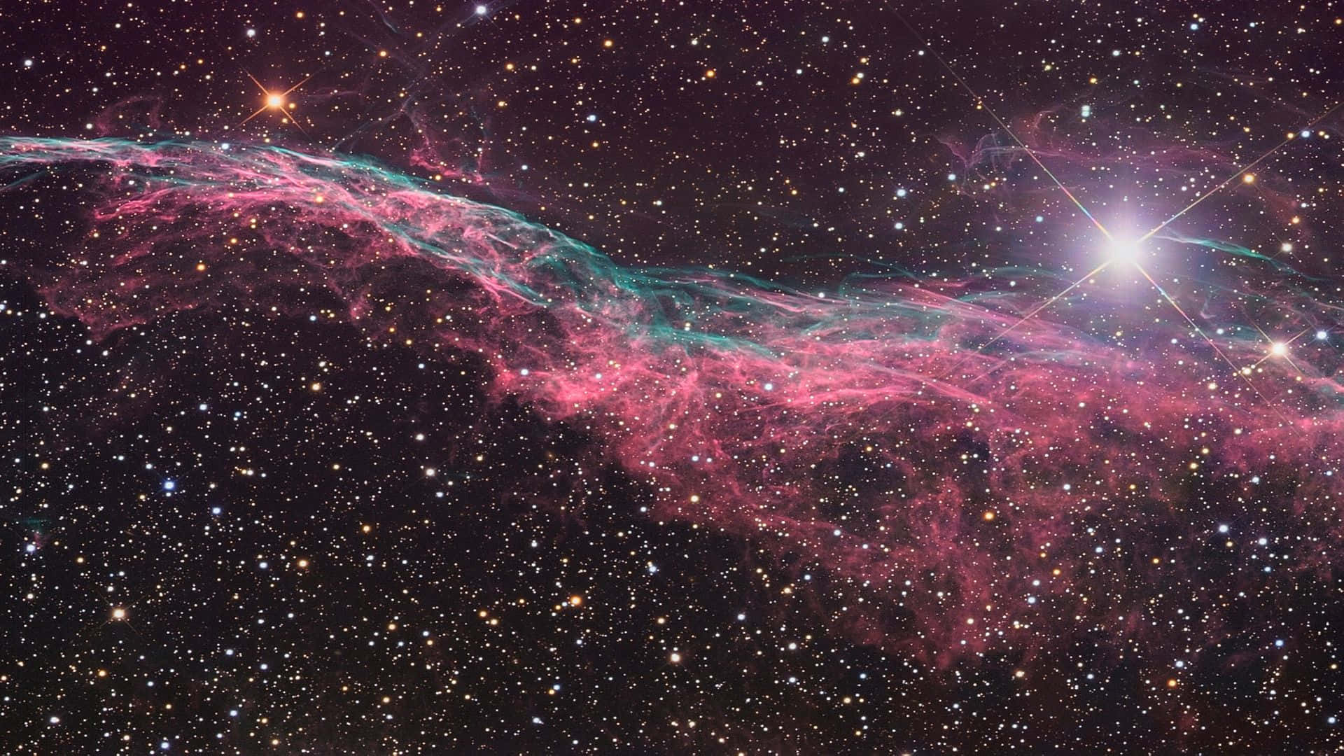一個色彩繽紛的星雲，帶有粉紅色和藍綠色的雲，在深空中無數星星之間發光。