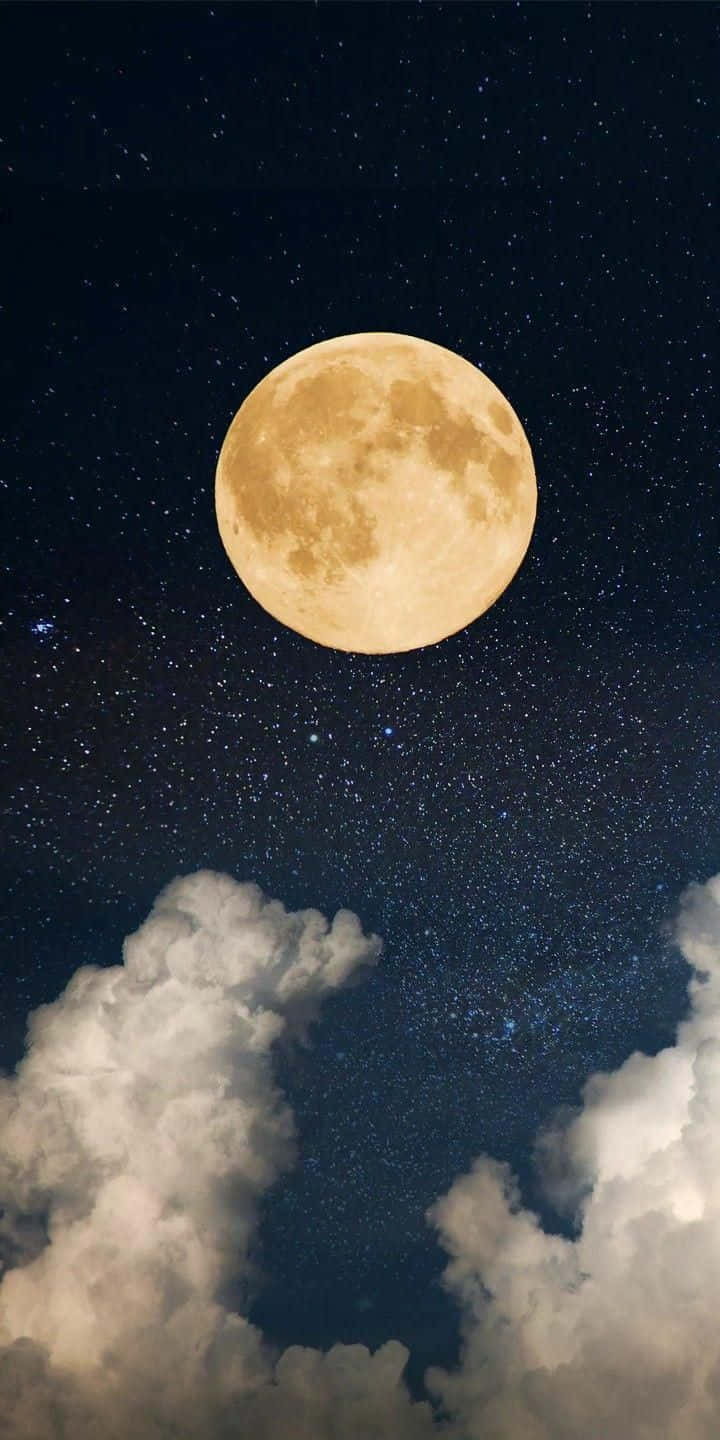 滿月在繁星夜空下，於蓬鬆雲朵上方明亮照耀。