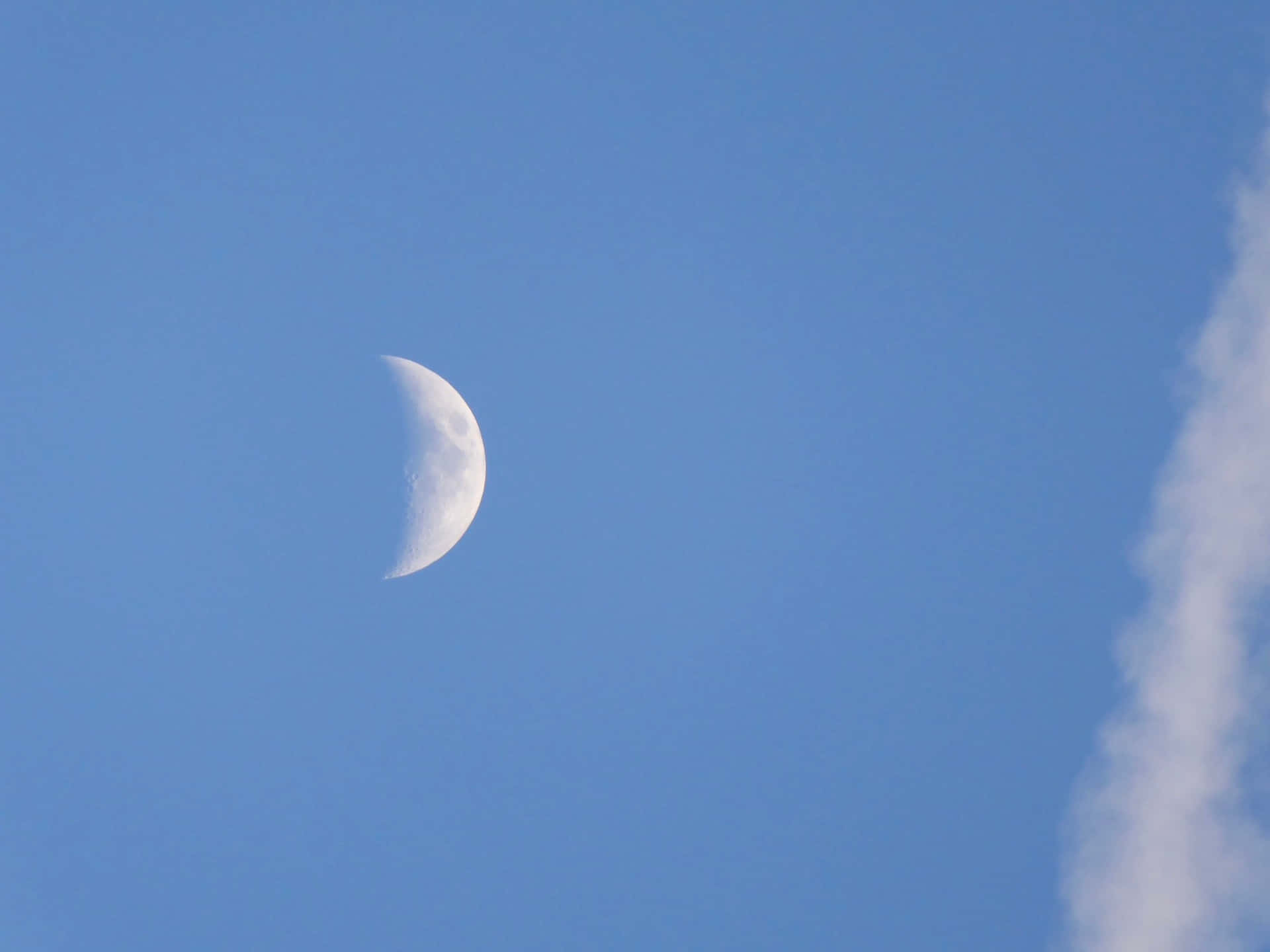 清澈藍天中的月牙與輕雲
