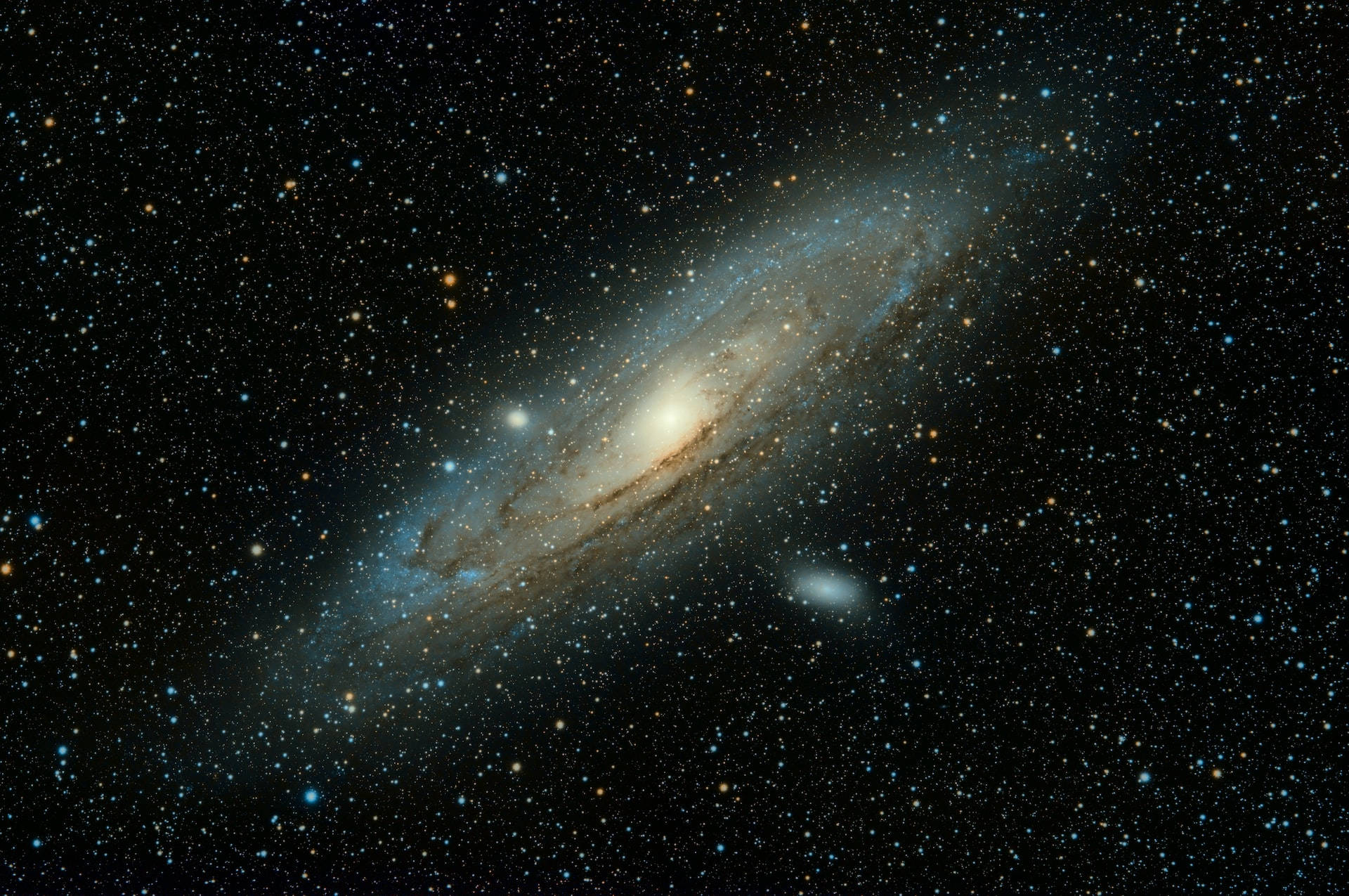 一個螺旋星系，帶有藍色和金色的旋臂，被深空的星星環繞。