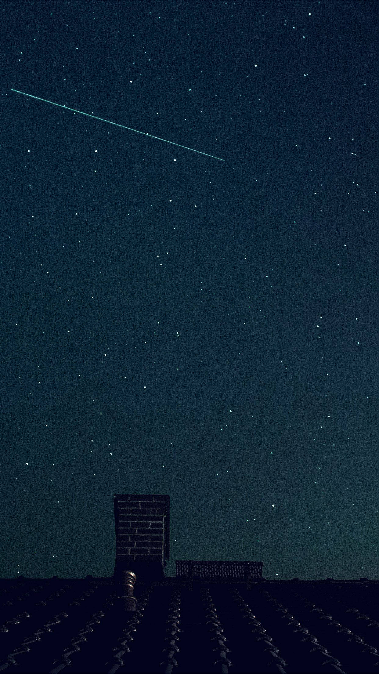 藍天 桌布 壁紙 — 繁星點點的夜空，一顆明亮的流星劃過黑暗的瓦片屋頂和磚砌煙囪上方。
