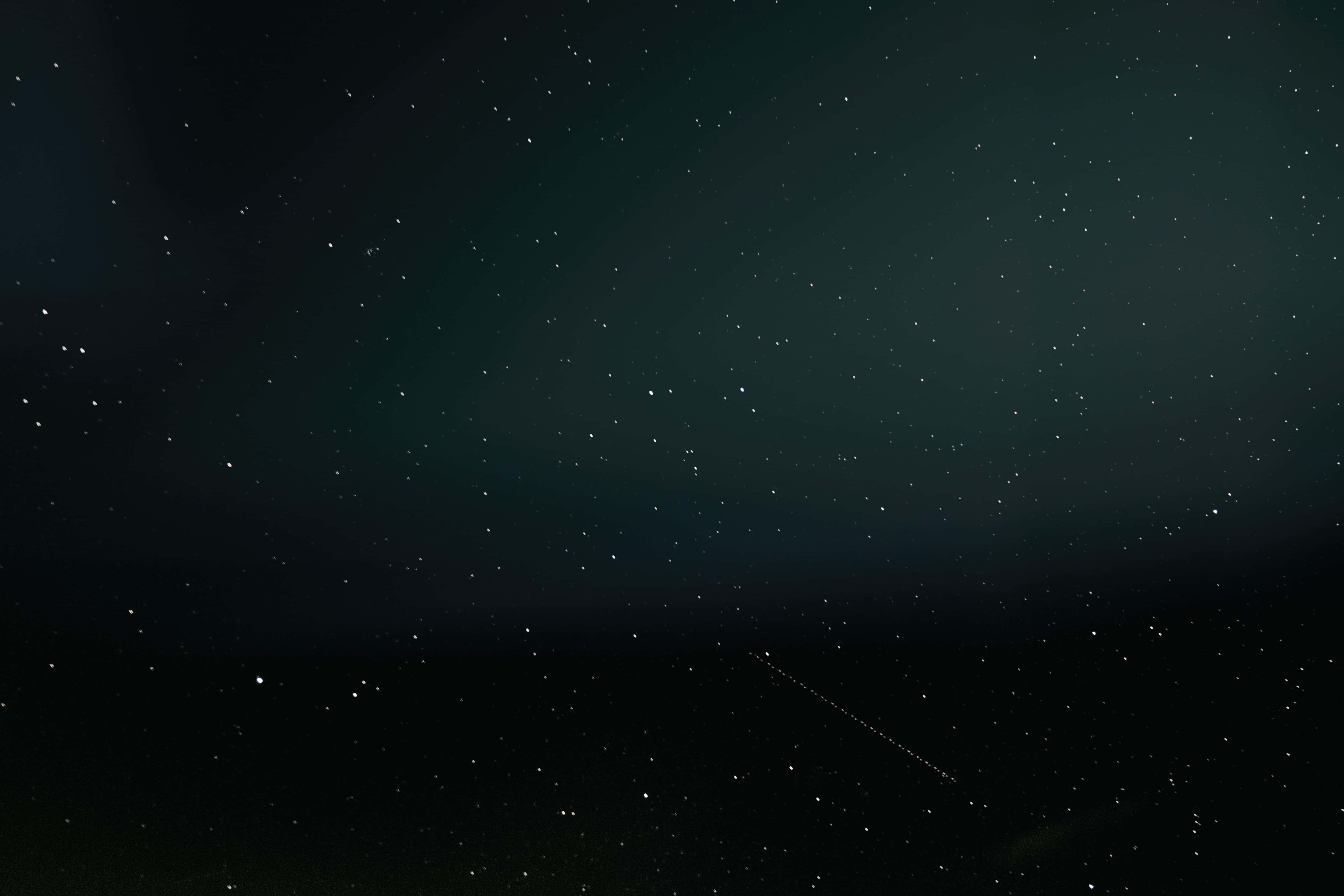 Motion Blur 桌布 壁紙 — 繁星點點的夜空，一顆明亮的流星劃過微弱地平線上的黑暗空間。