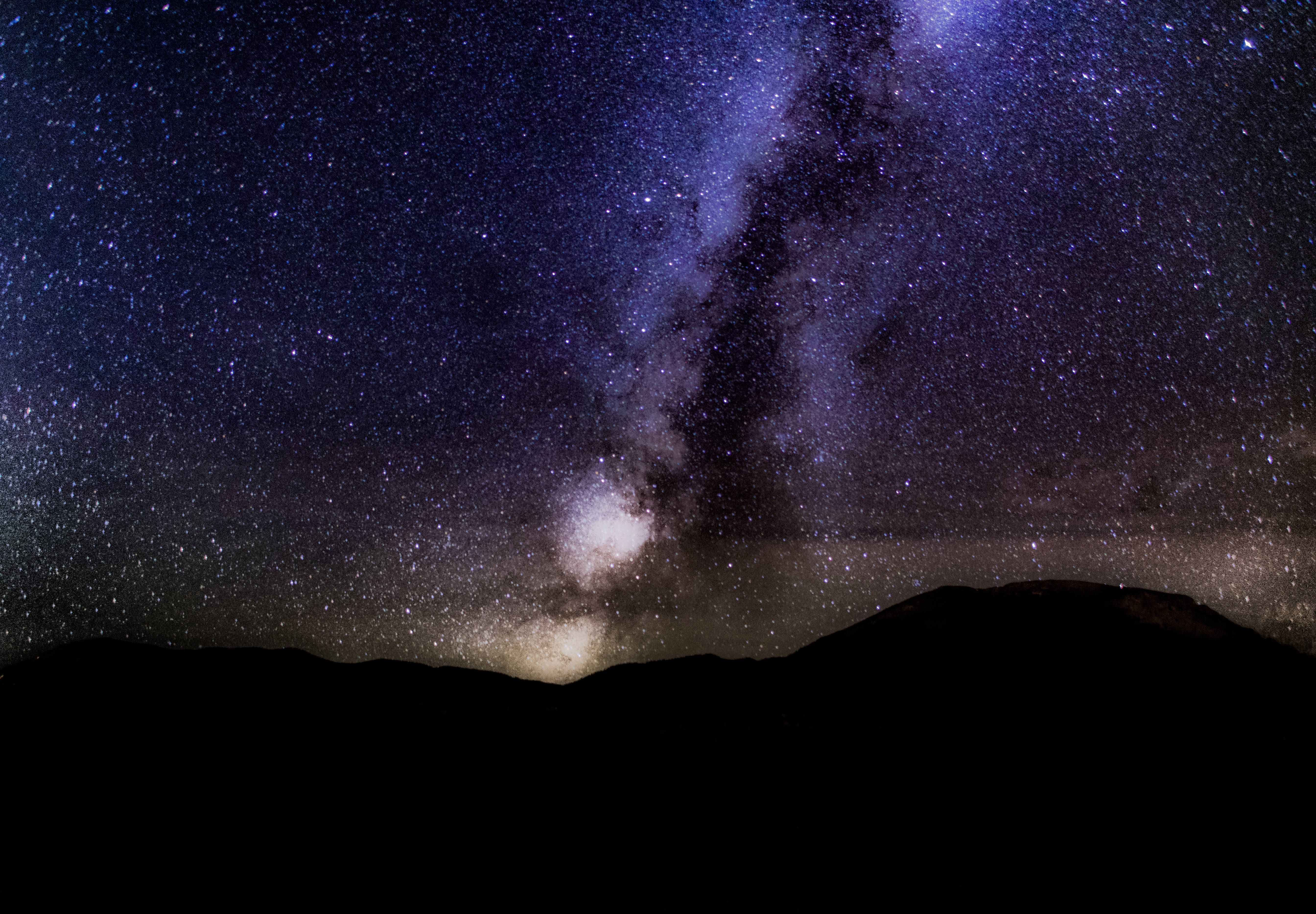 繁星點點的深紫色夜空 壁紙 — 令人嘆為觀止的銀河系景觀，在黑暗山脈剪影上方，橫跨滿天繁星的夜空。