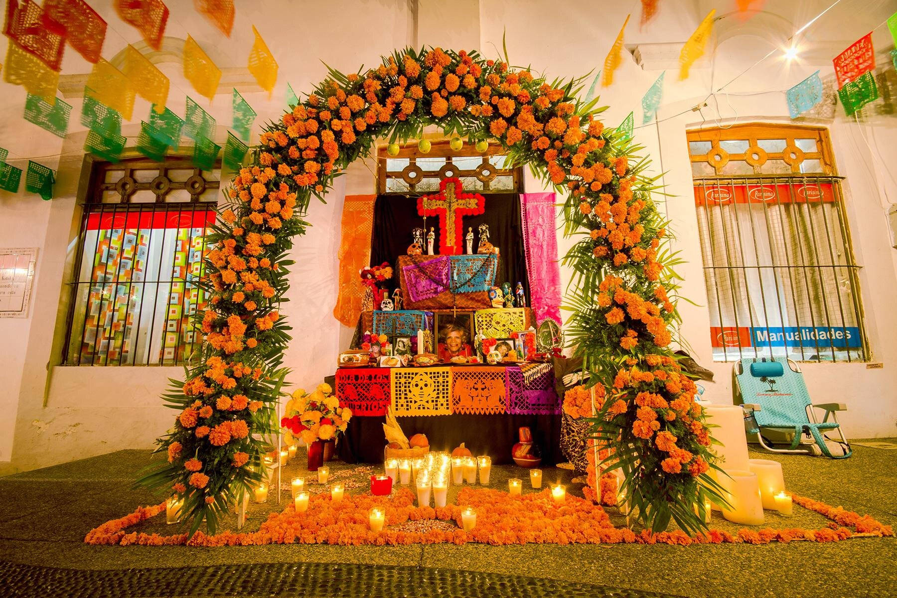 一個裝飾過的亡靈節祭壇，有萬壽菊、蠟燭和 papel picado。