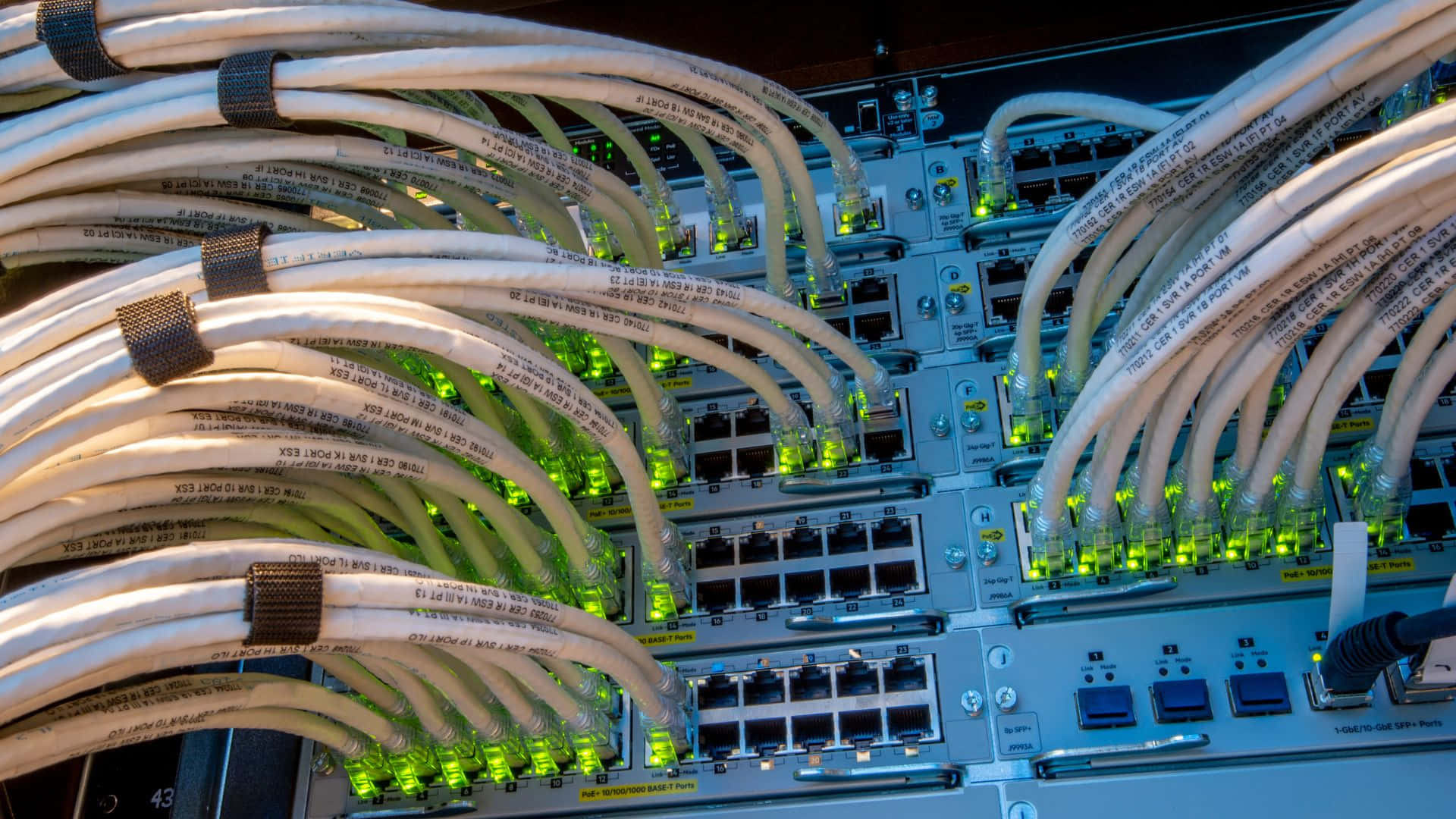Gaming Servers 桌布 壁紙 — 纏繞的白色網絡電纜帶有發光的綠色燈光，連接到數據中心的服務器機架。