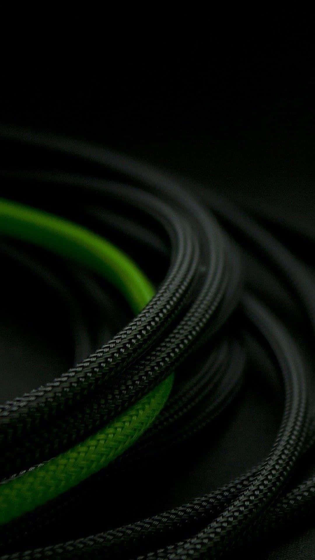 Green Phone 桌布 壁紙 — 纏繞的黑色編織線纜帶有鮮豔的綠色條紋，在深黑色背景上隱約發光。