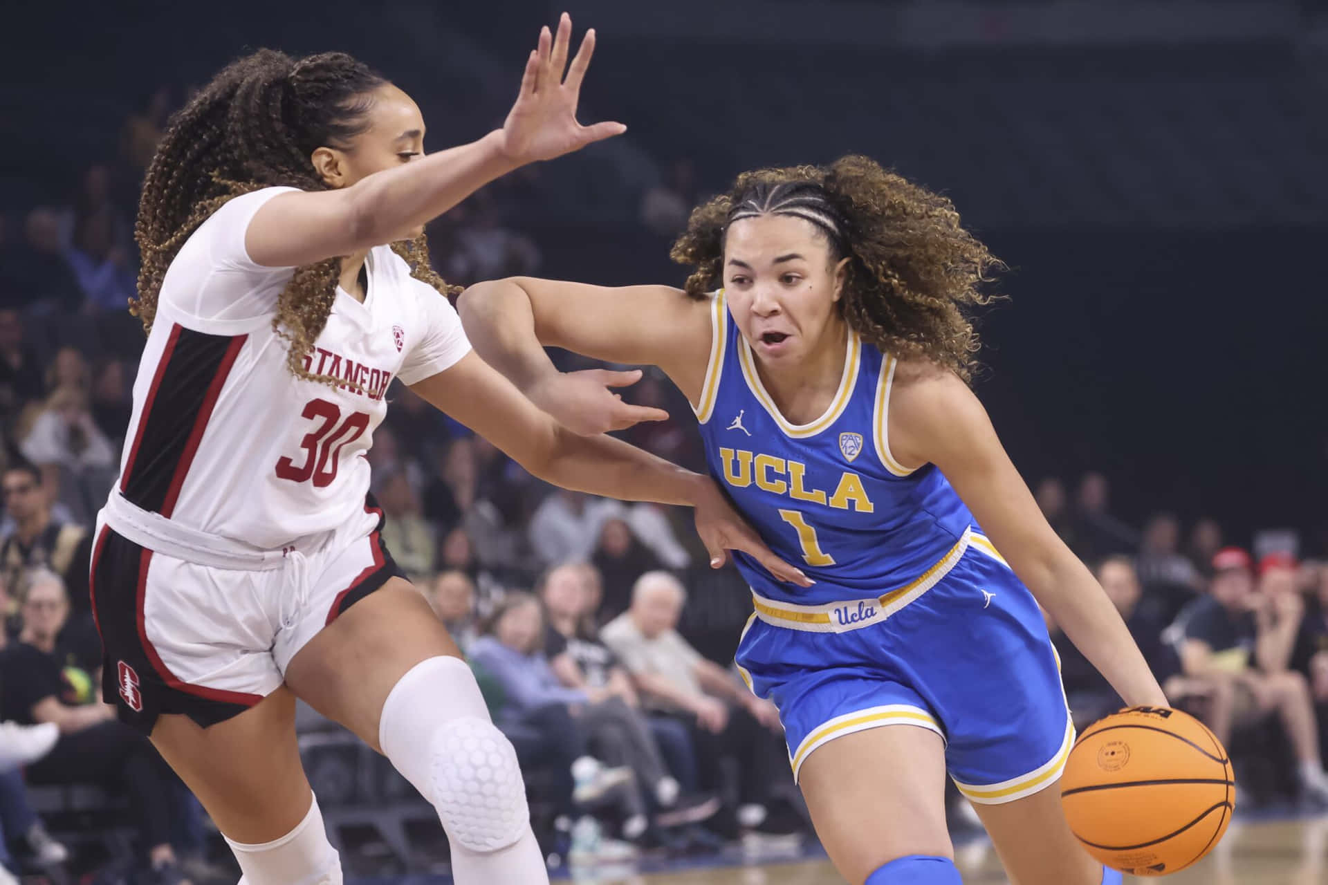 UCLA籃球球員在比賽中運球越過史丹福防守球員。