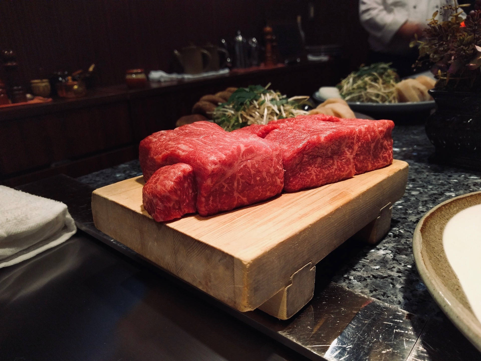餐廳木板上嘅兩塊厚切大理石紋牛肉。