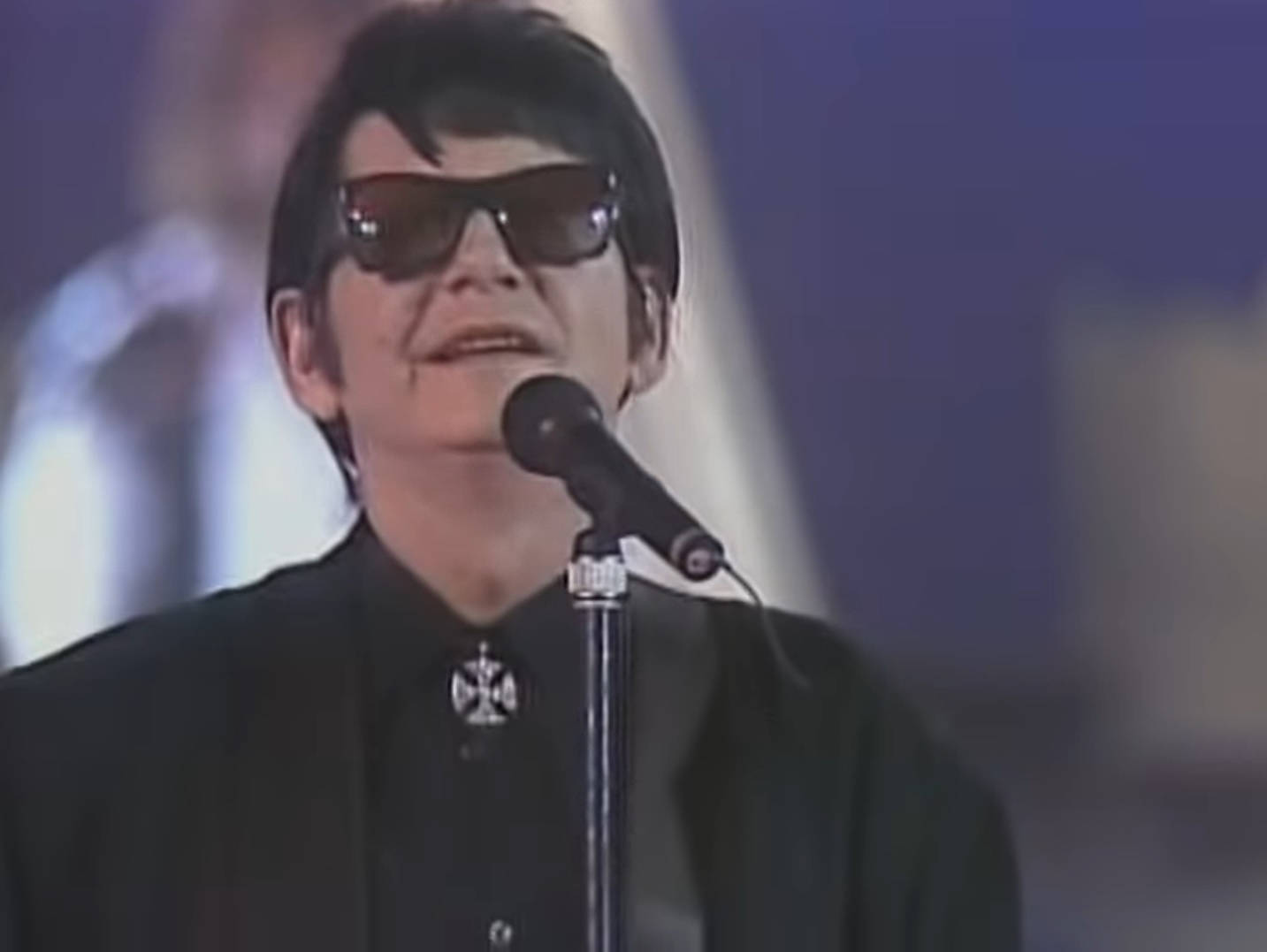 戴太陽眼鏡的歌手在舞台上用咪高峰表演