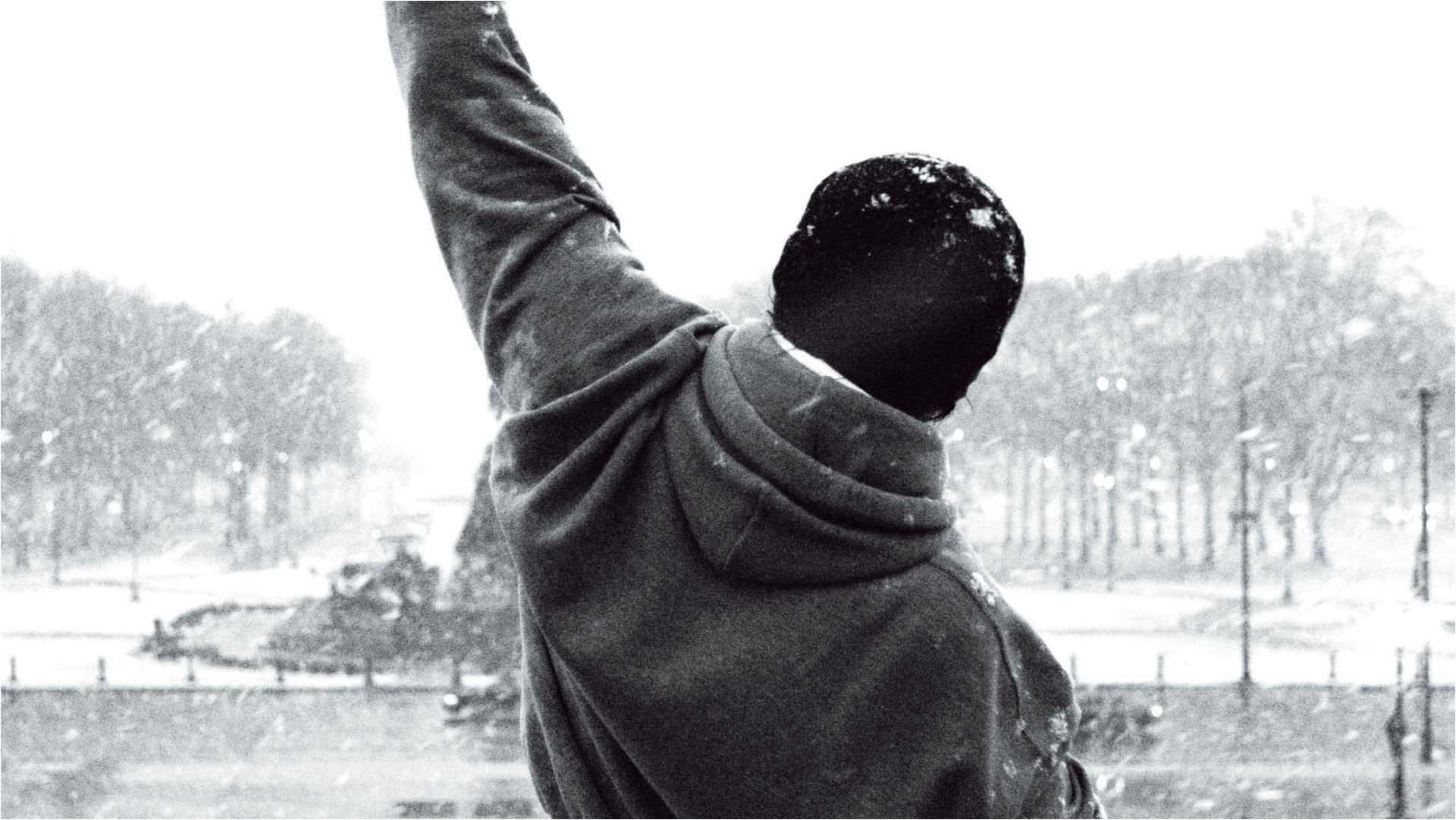 冬天在雪地公園裡舉起手臂的連帽衫人物