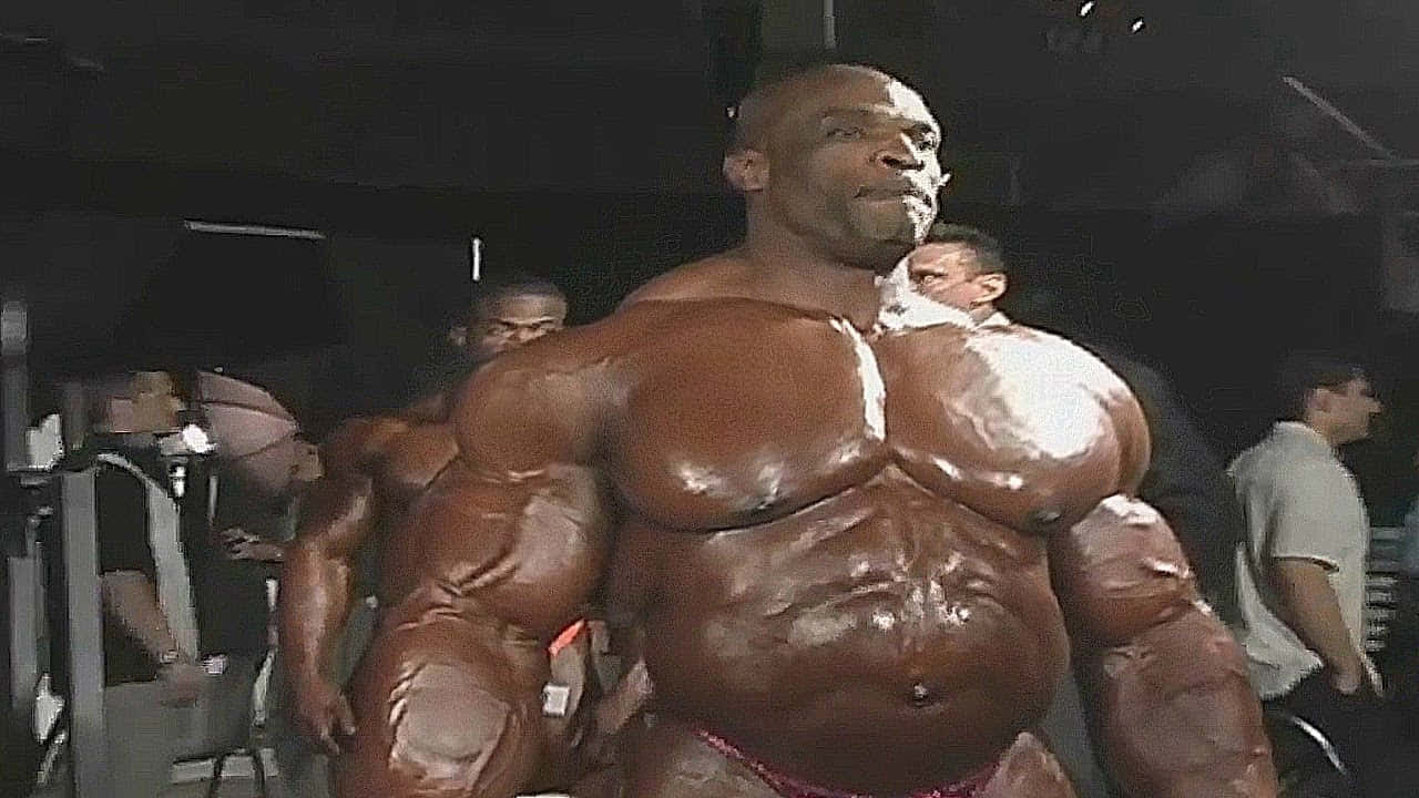 一位肌肉發達、塗滿油的健美運動員在比賽期間在舞台上擺姿勢。