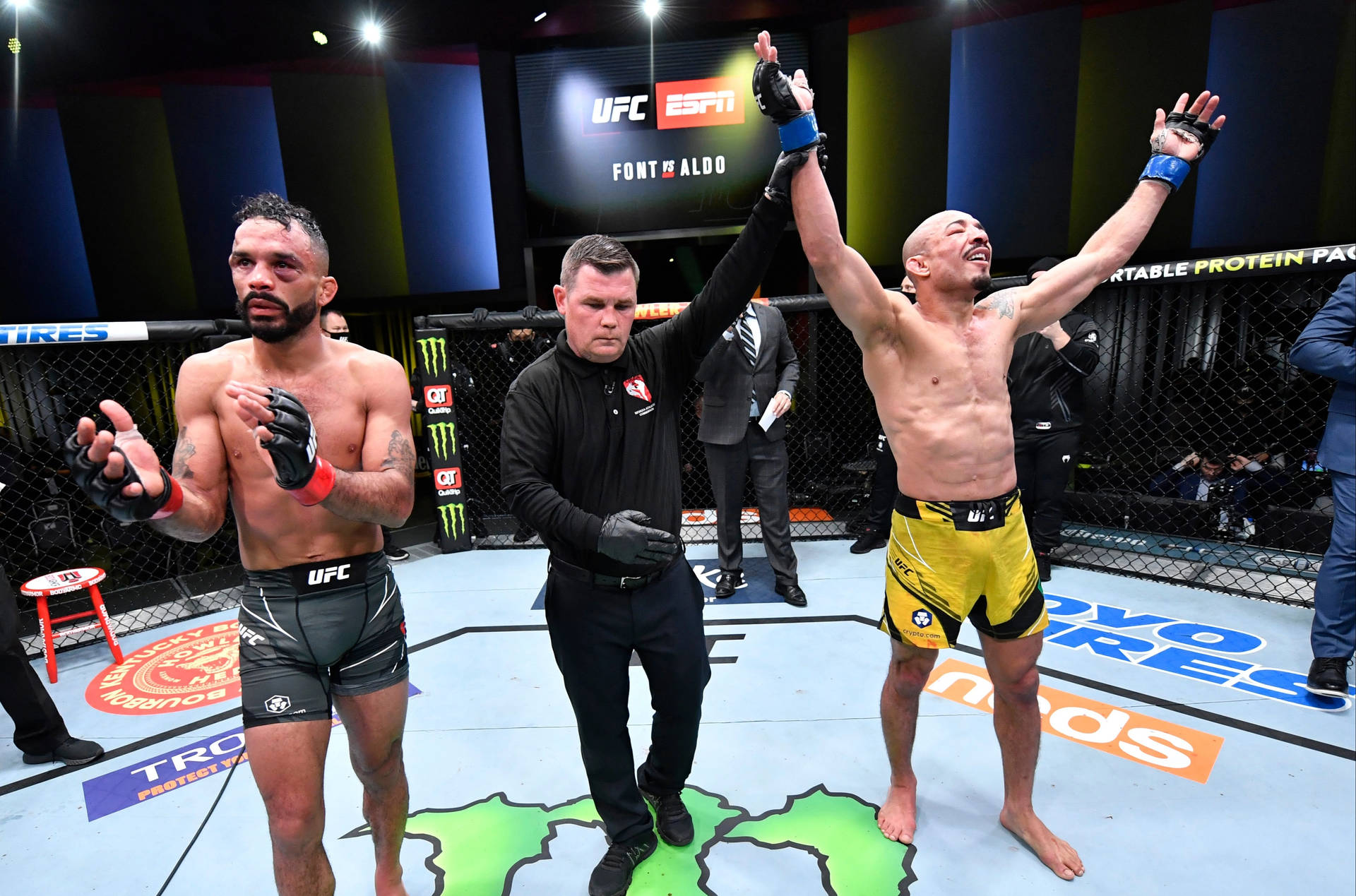 UFC 拳手在八角籠中贏得比賽，裁判舉起他的手。