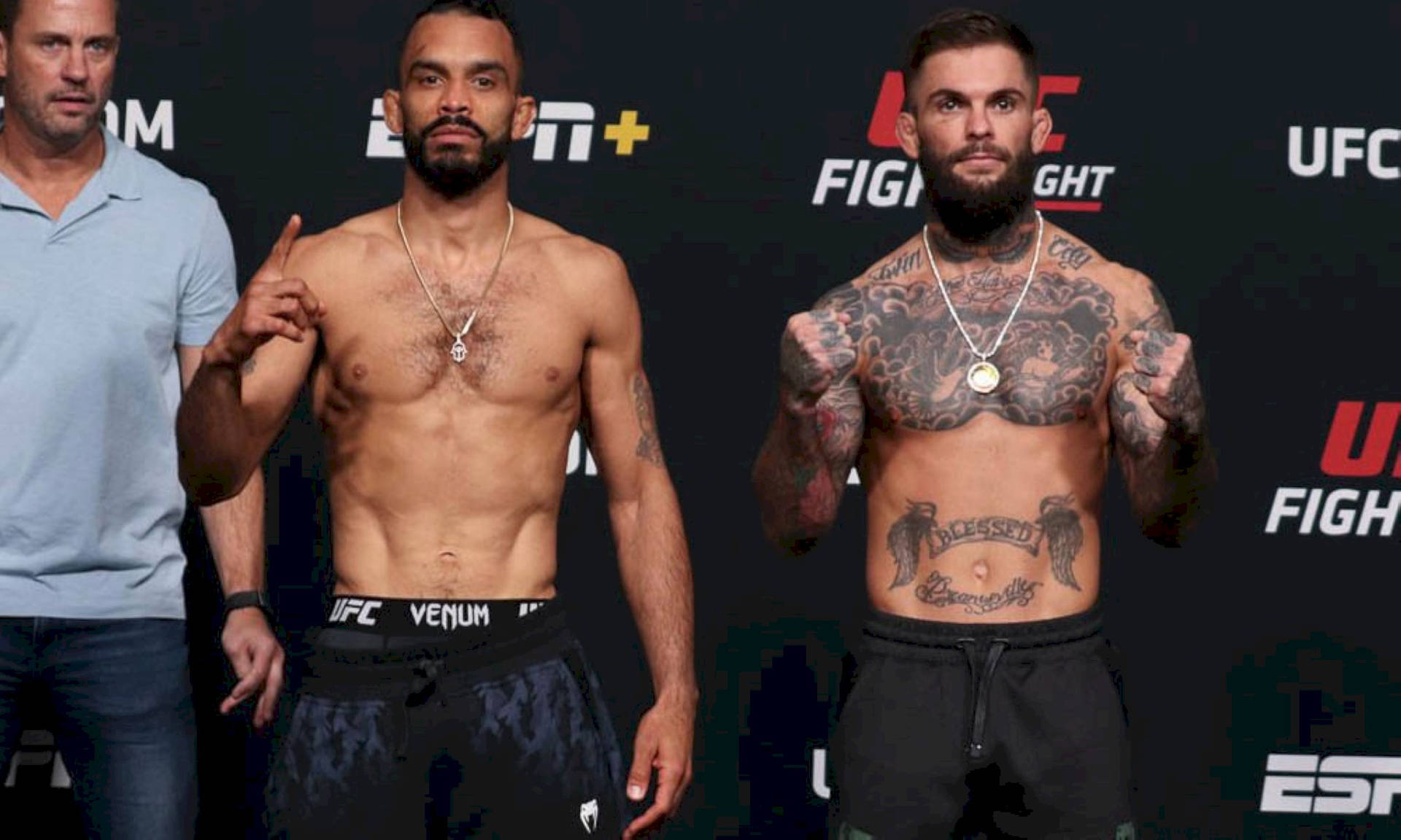兩名赤裸上身、有紋身的男性UFC拳手為稱重活動擺姿勢。